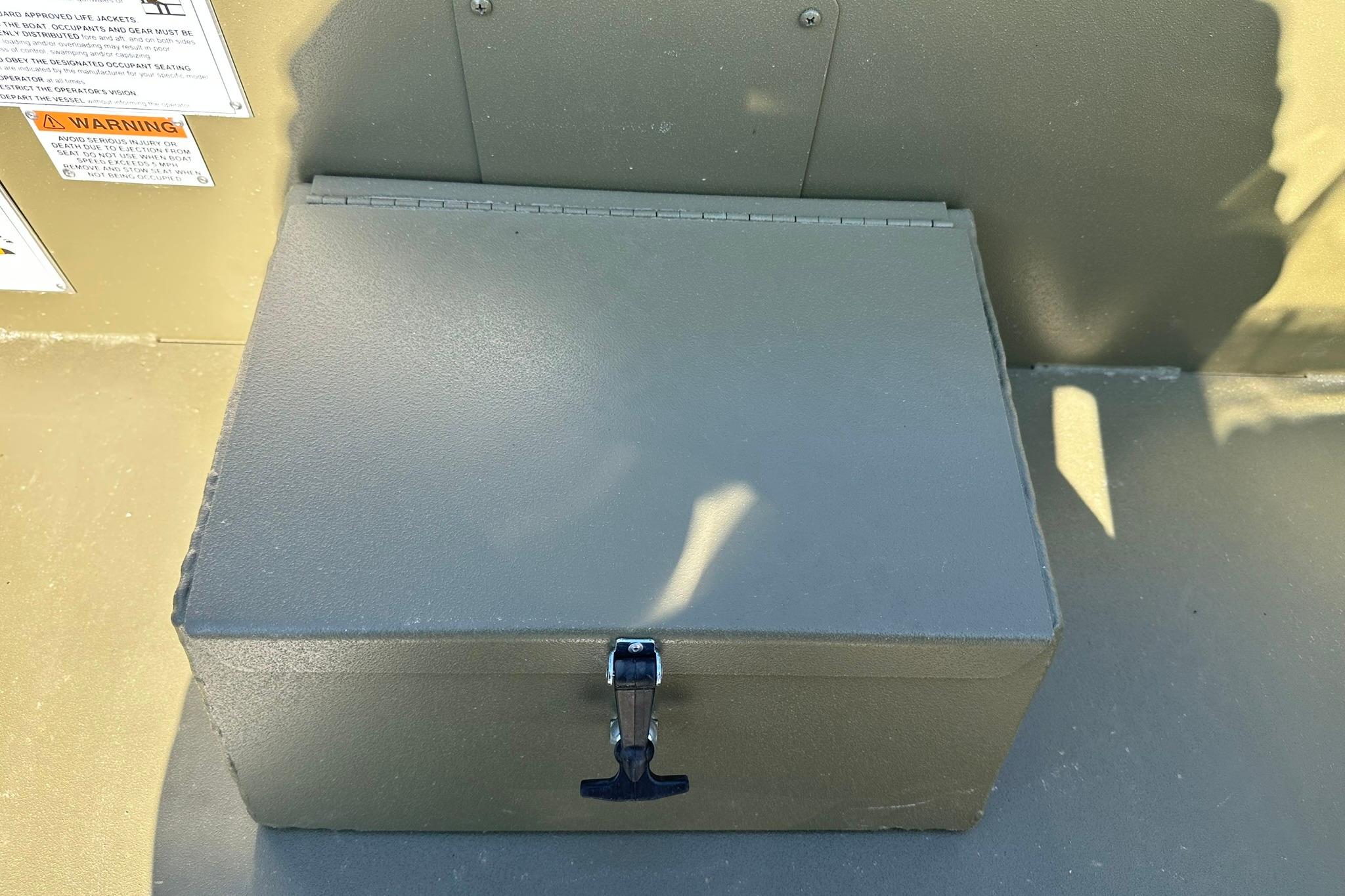 Storage compartment on a 2026 Lowe Roughneck 1860SC boat, featuring a secure latch.