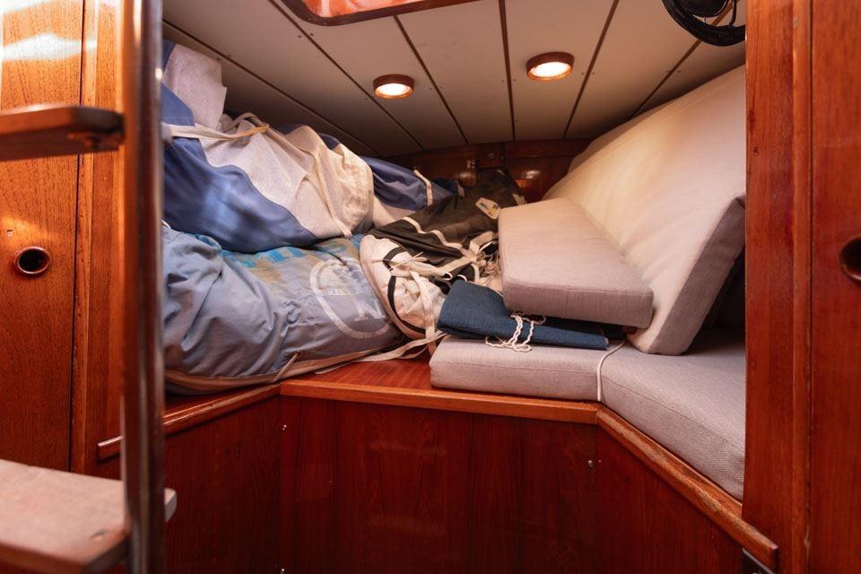 Interior cabin of 1982 Nautor Swan 65 yacht with cushions and sails.