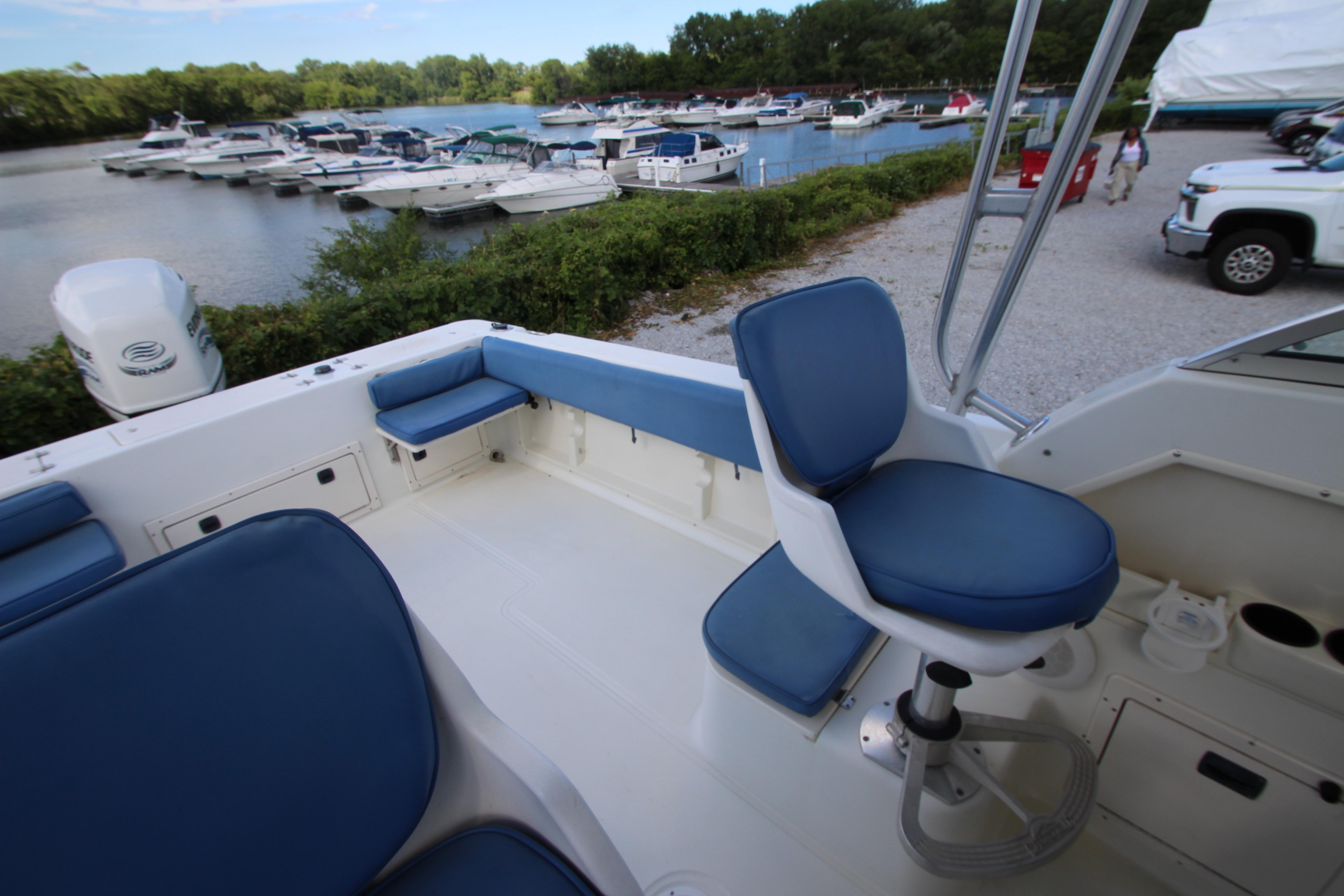 2002 Hydra-Sports 230 WA boat interior with blue seating, docked near a marina.