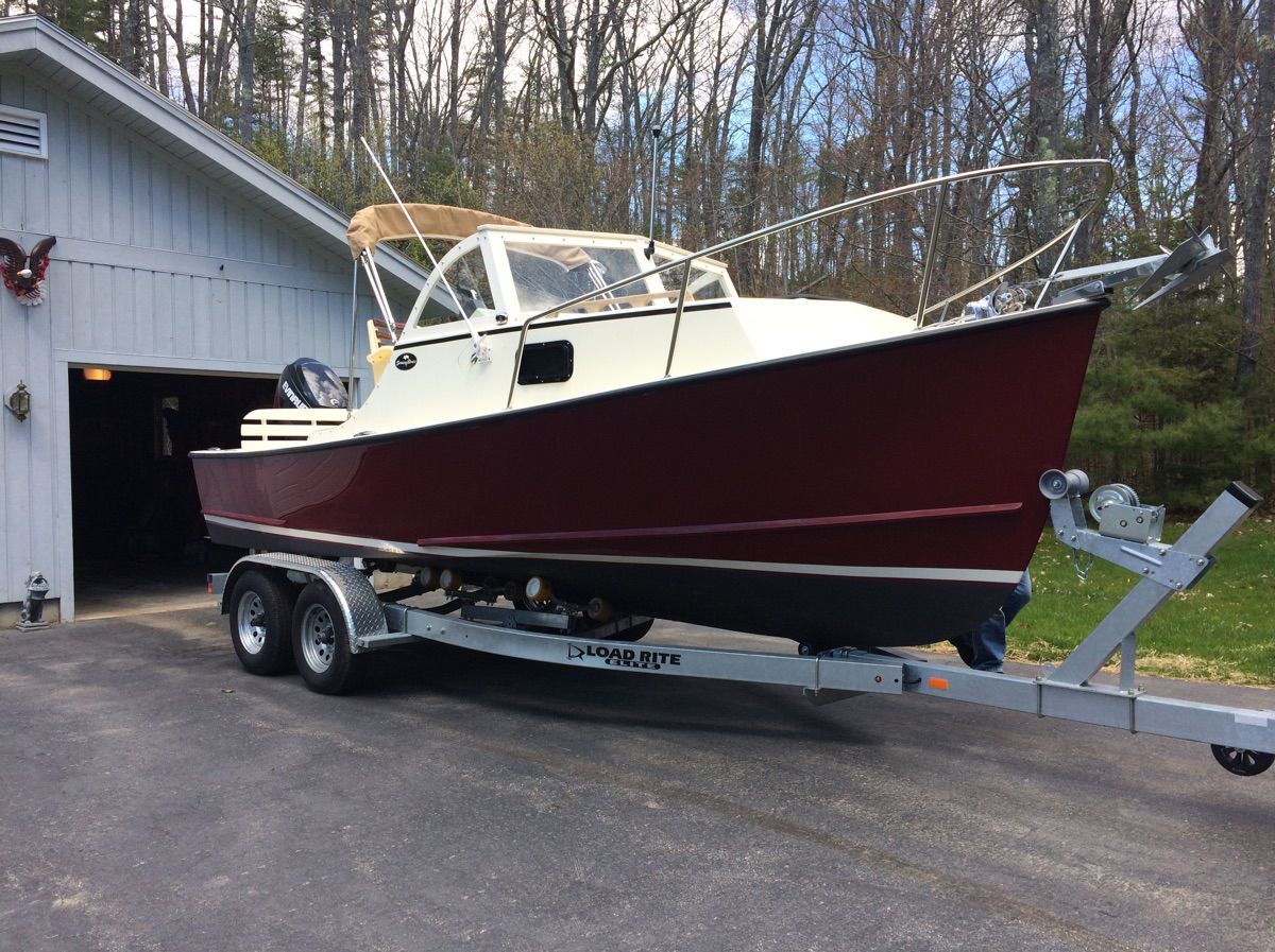 A 2018 Seaway Seafarer 21 boat on a trailer in front of a garage.