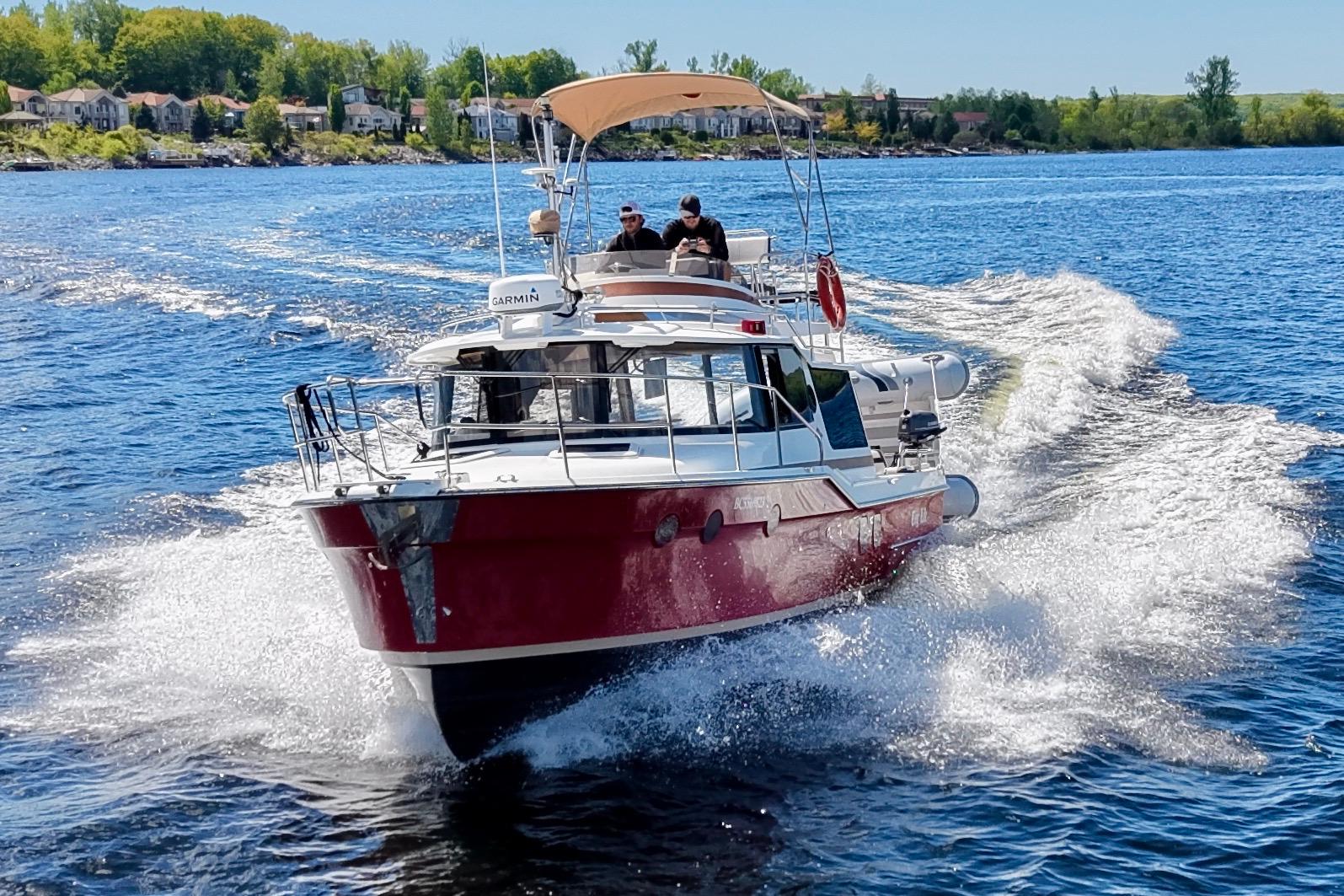2017 Ranger Tugs R-29 CB cruising on a scenic lake with lush shoreline.