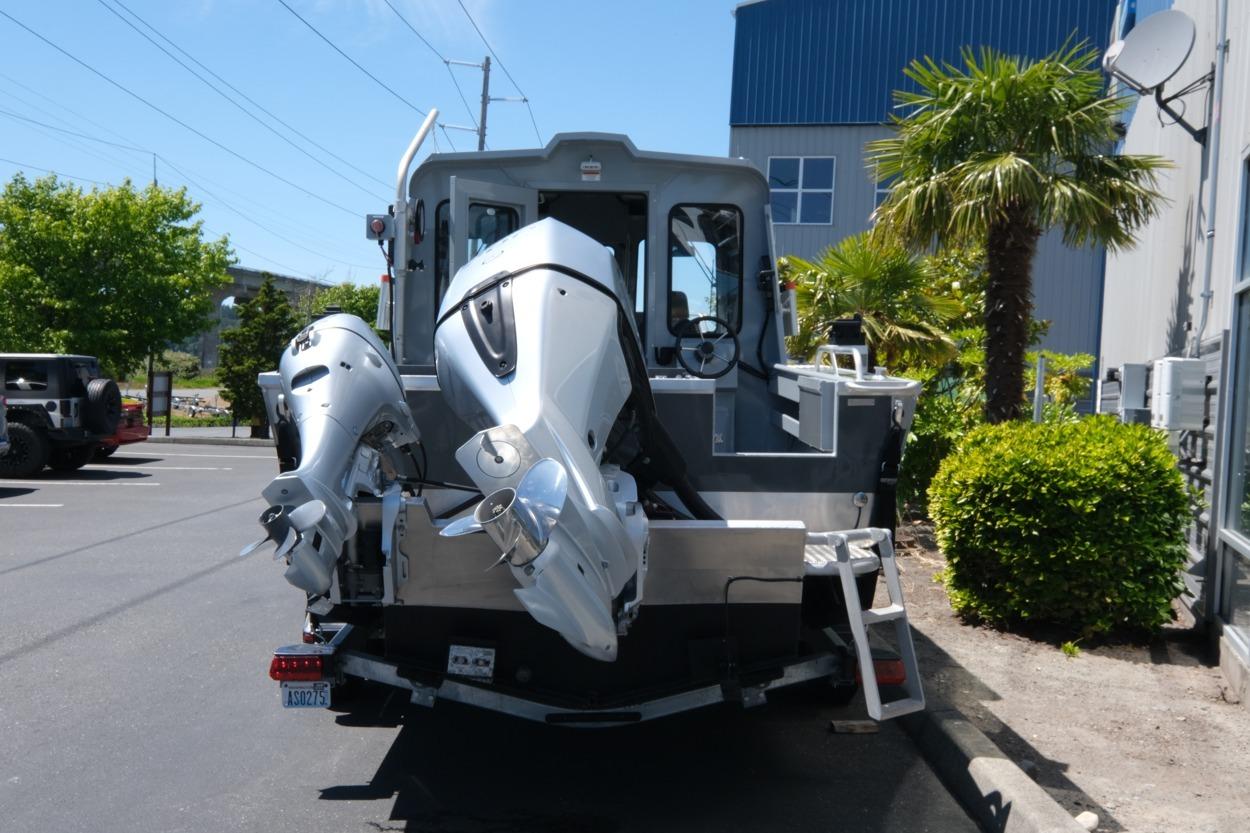 2018 Hewescraft 220 Ocean Pro ET Hardtop with dual outboard motors in a parking lot.