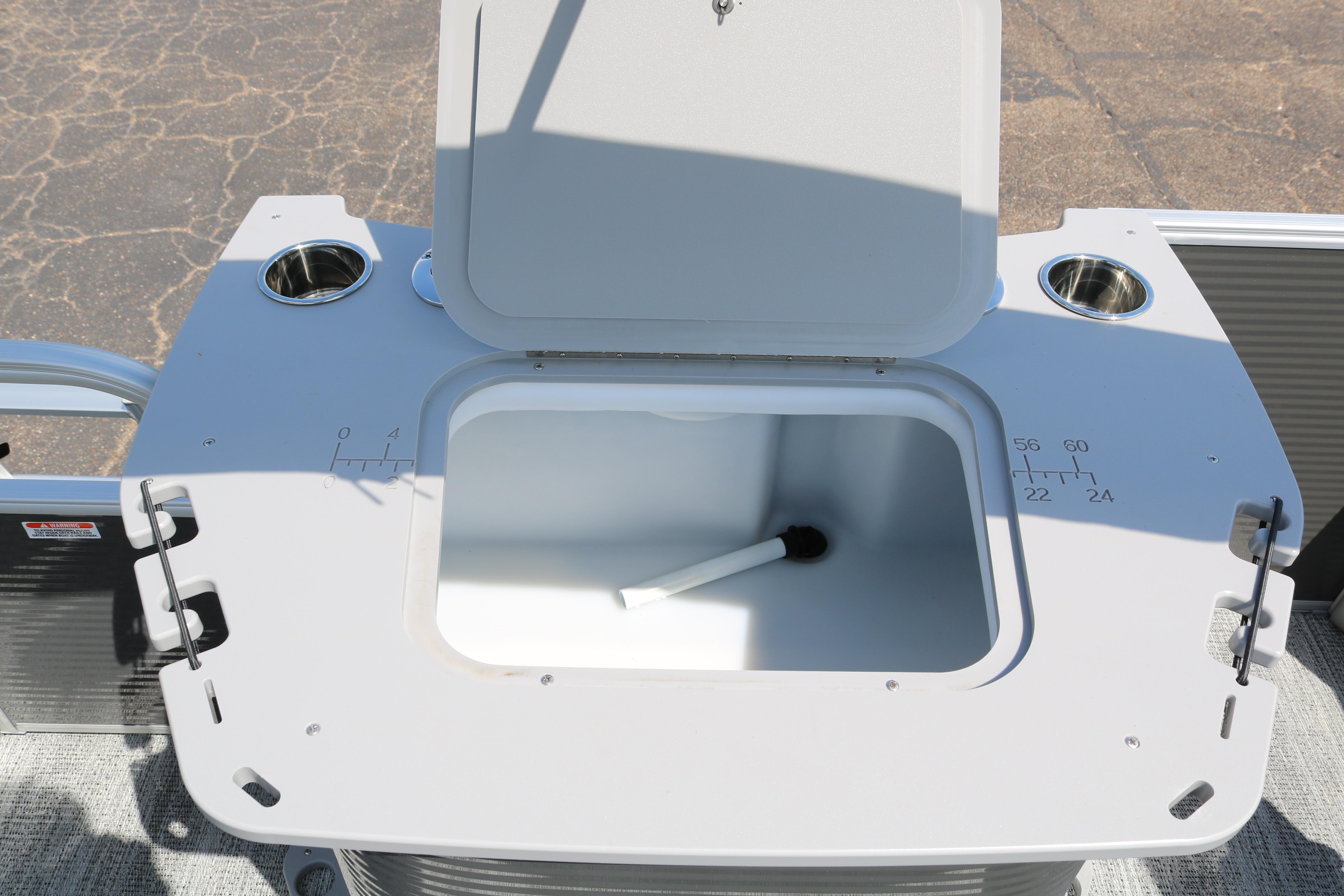 Open storage compartment on 2026 Bennington 20SXSNP REAR FISH boat with cup holders.