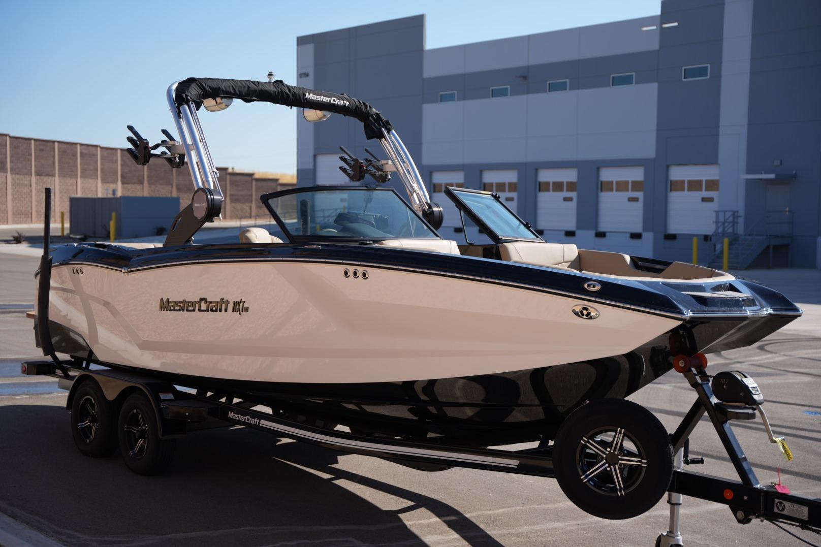 2023 MasterCraft NXT24 boat on trailer in industrial setting.