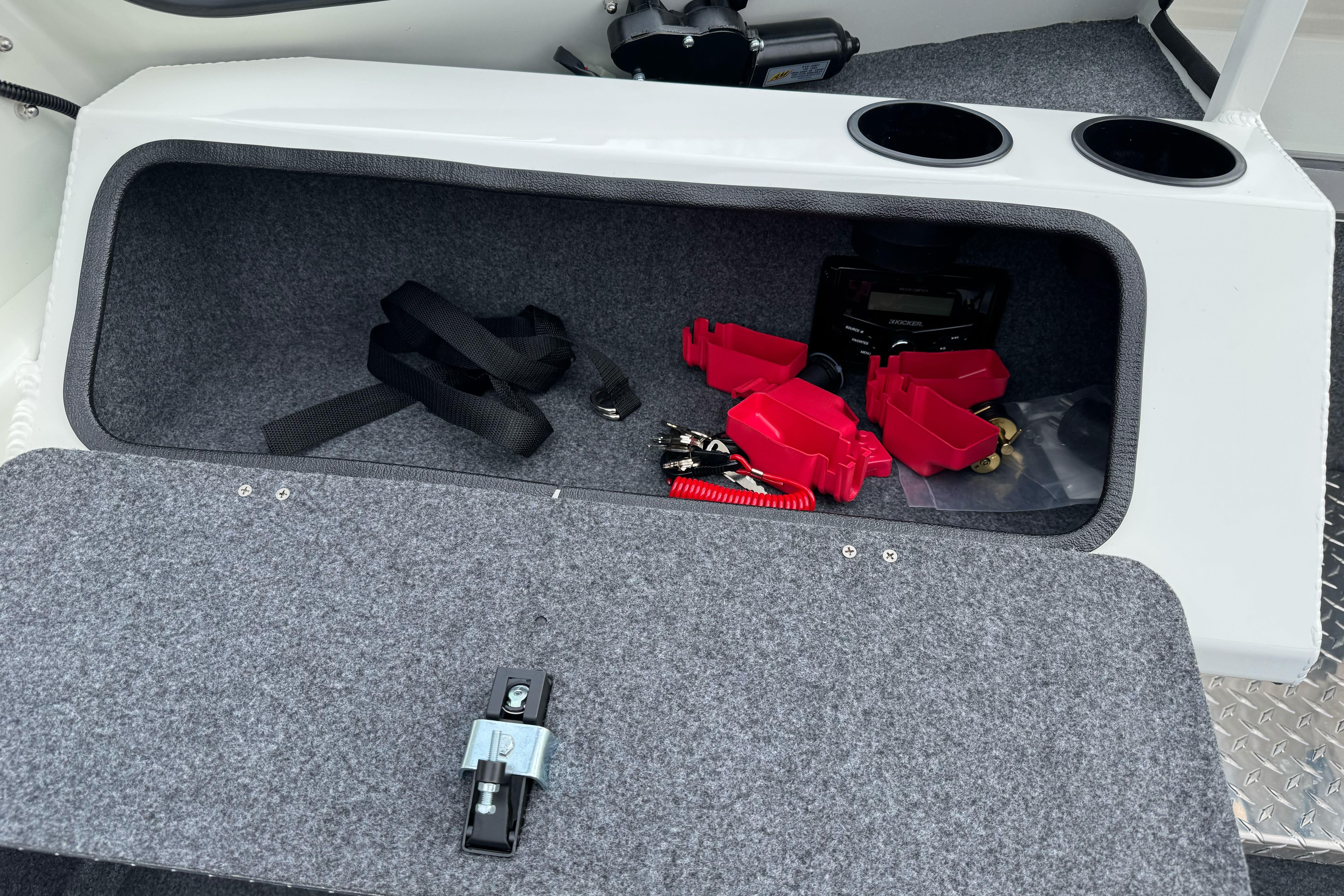 Storage compartment in 2026 Lund 185 Heavy Gauge boat with accessories and cup holders.