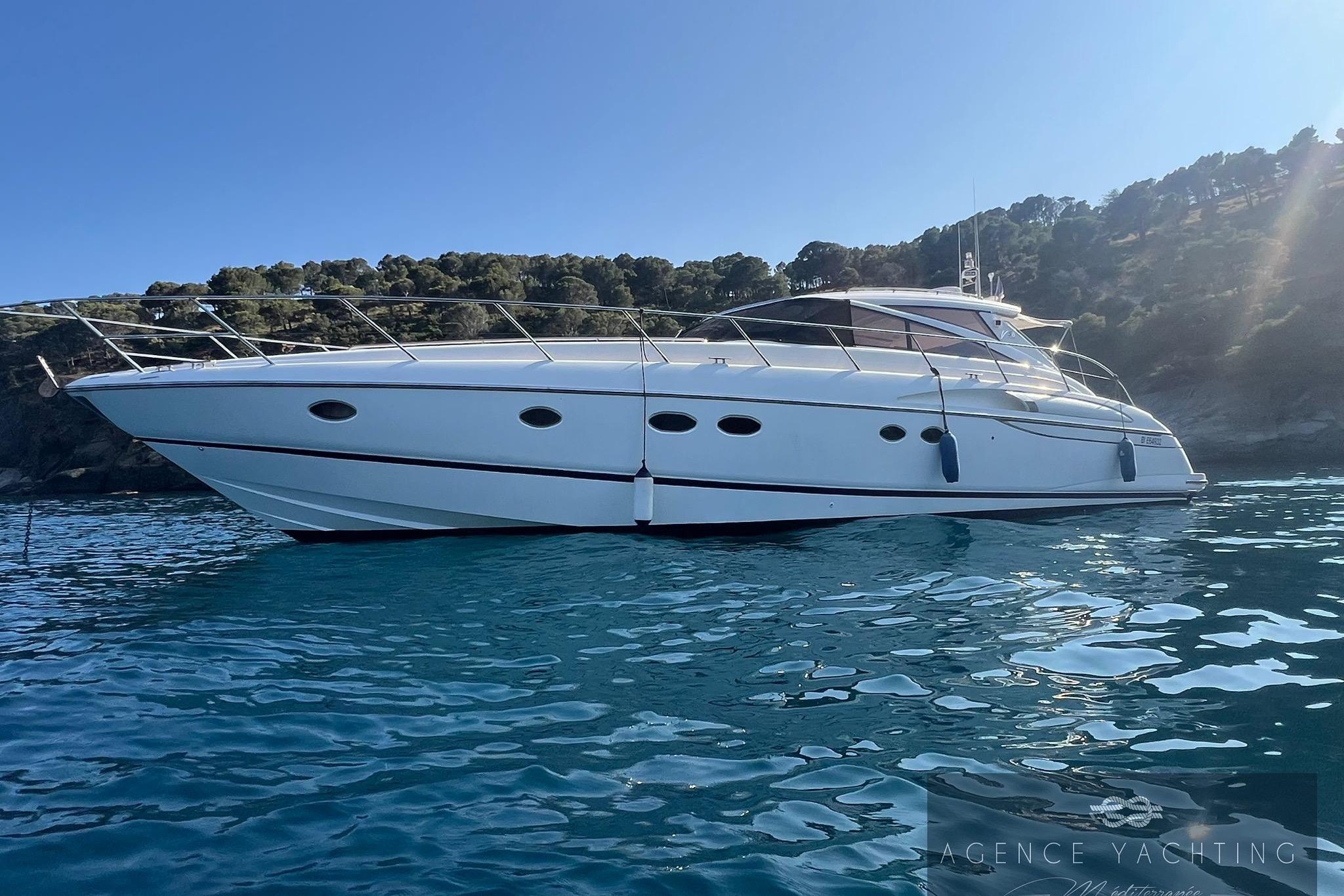 2004 Princess V58 yacht on serene blue water with scenic background.