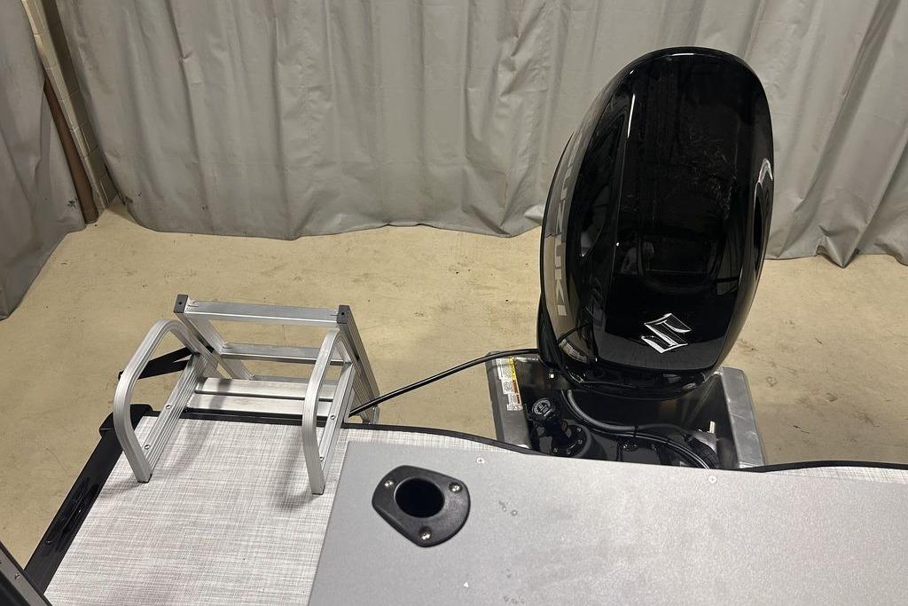 2026 Dockside 22DF boat with outboard motor and aluminum ladder in a garage setting.
