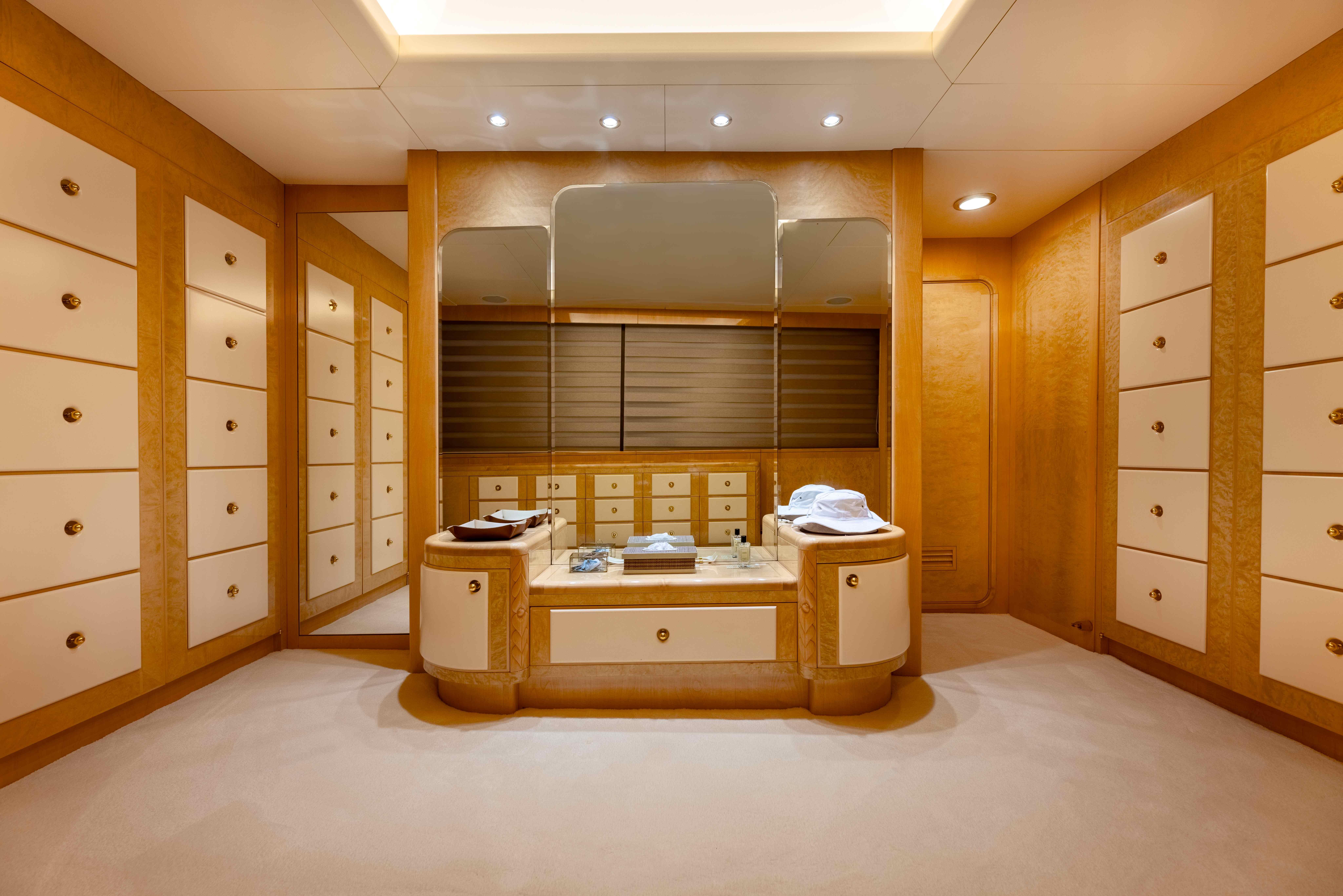 Luxurious yacht interior with elegant wood cabinetry, mirrors, and soft lighting, Custom 65M Cantieri Navali Nicoloni, 1987.