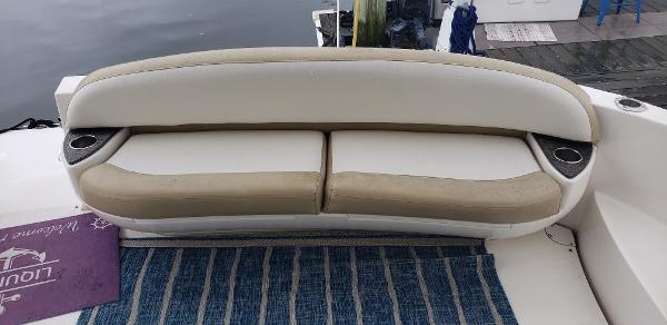 2010 Meridian 441 Sedan boat seating with striped rug and cup holders.