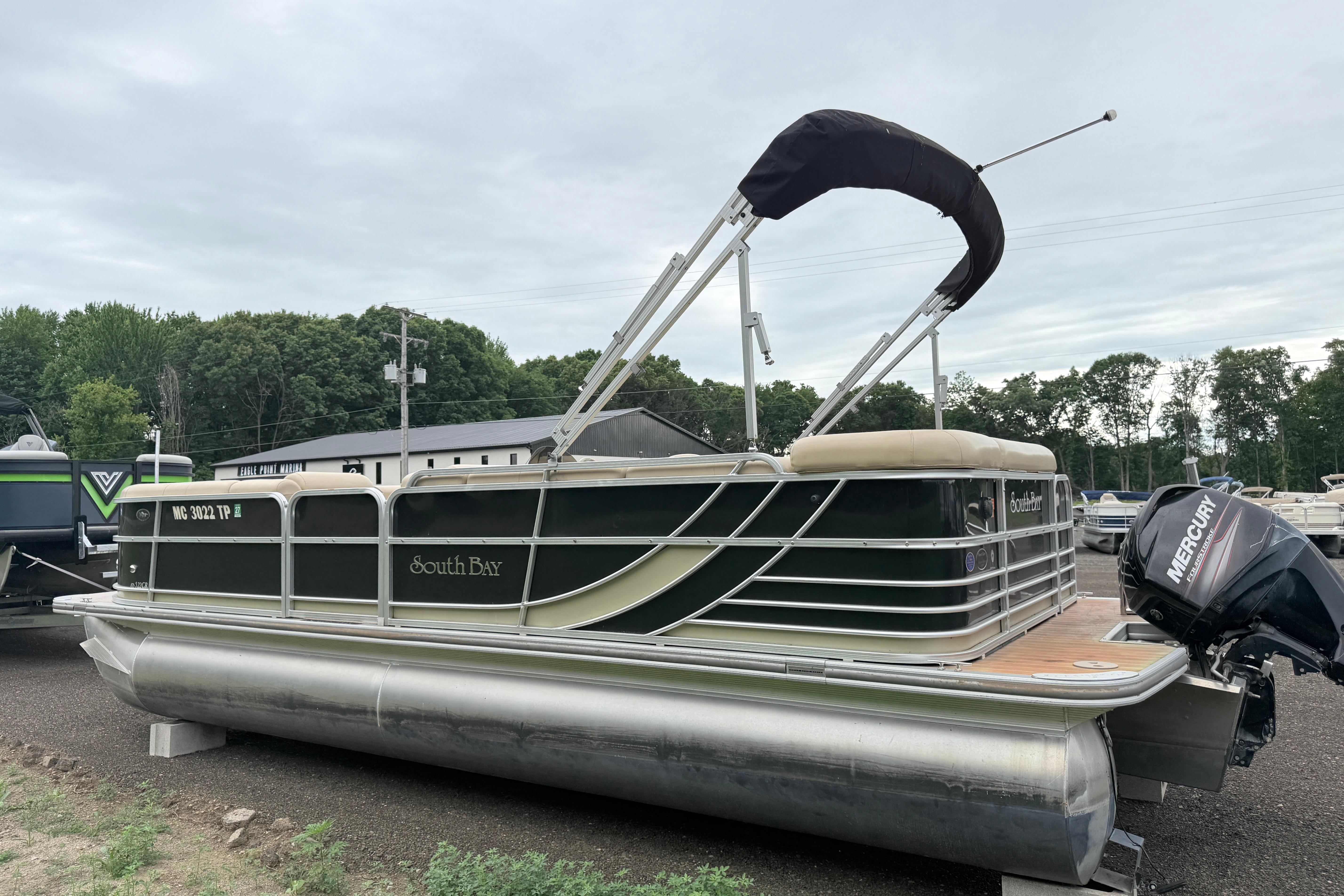 2013 South Bay 522CR pontoon boat with Mercury outboard motor, parked outdoors.