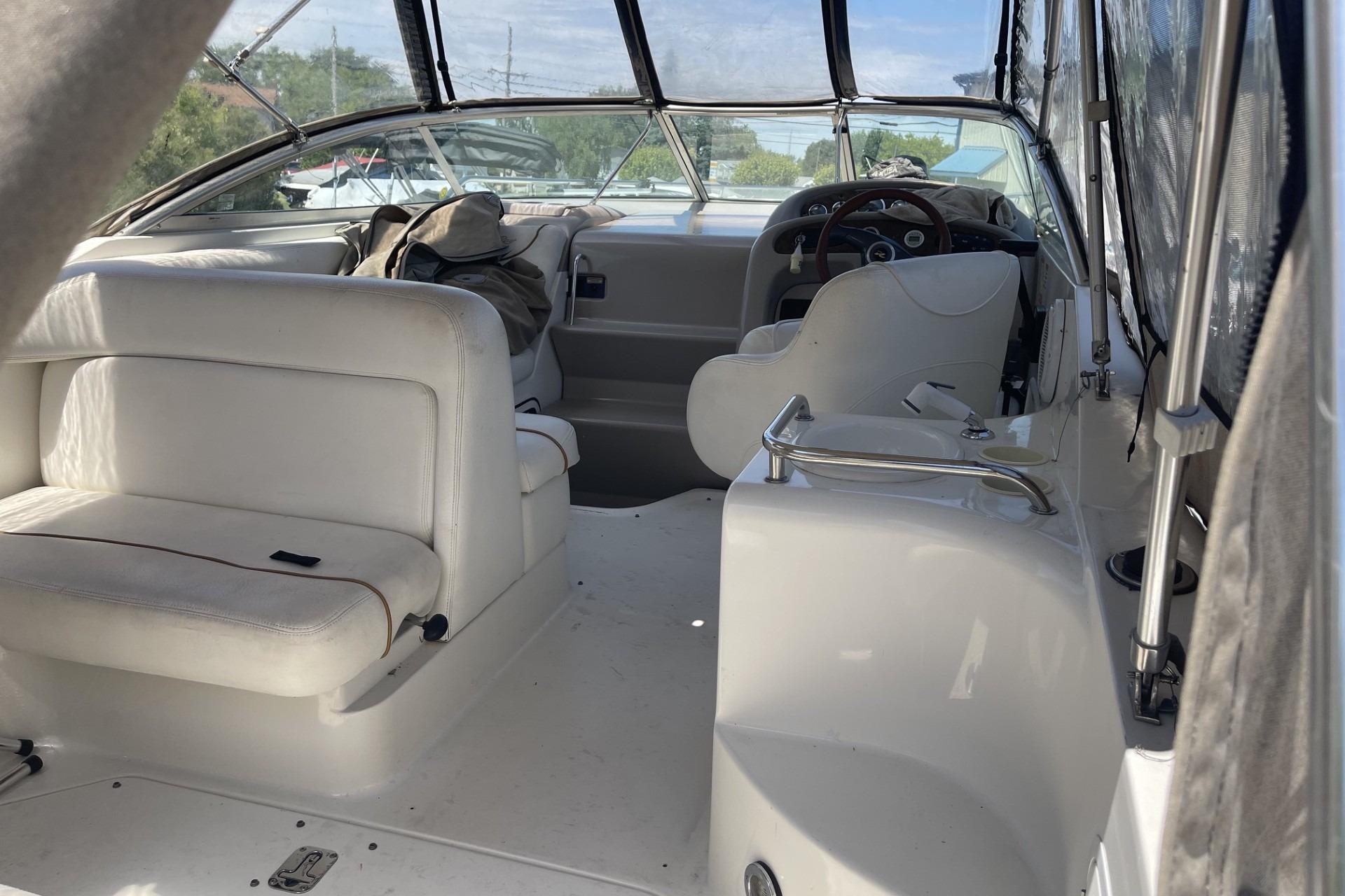 Interior of 2000 Sea Ray Sundancer 260 boat with white seating and steering area.