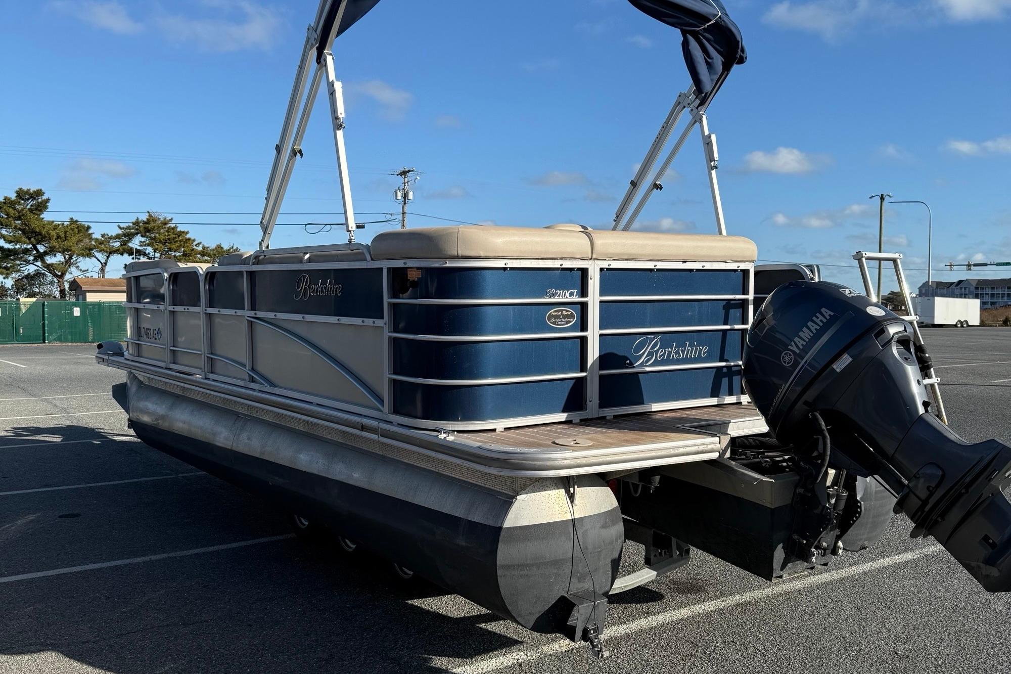 2012 Berkshire 210CL Premium pontoon boat with Yamaha outboard motor in parking lot.