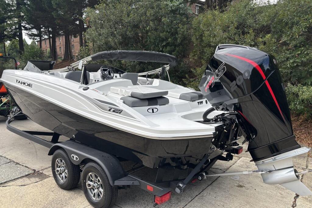 2026 Tahoe T21 boat on trailer with powerful outboard motor, parked outdoors.