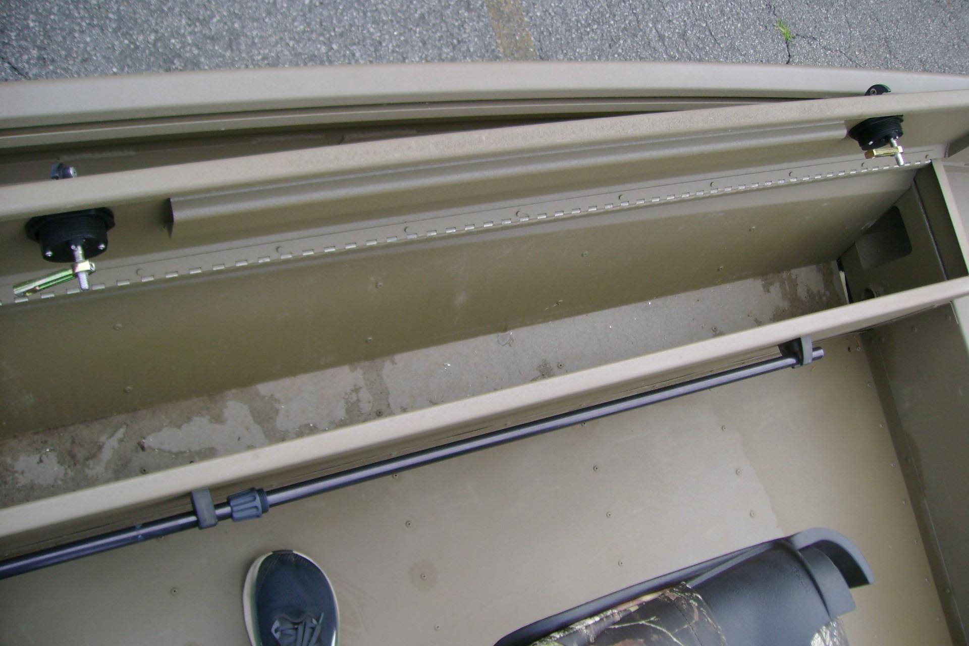 Interior view of 2023 G3 1652 DK boat showing storage compartment and seat.