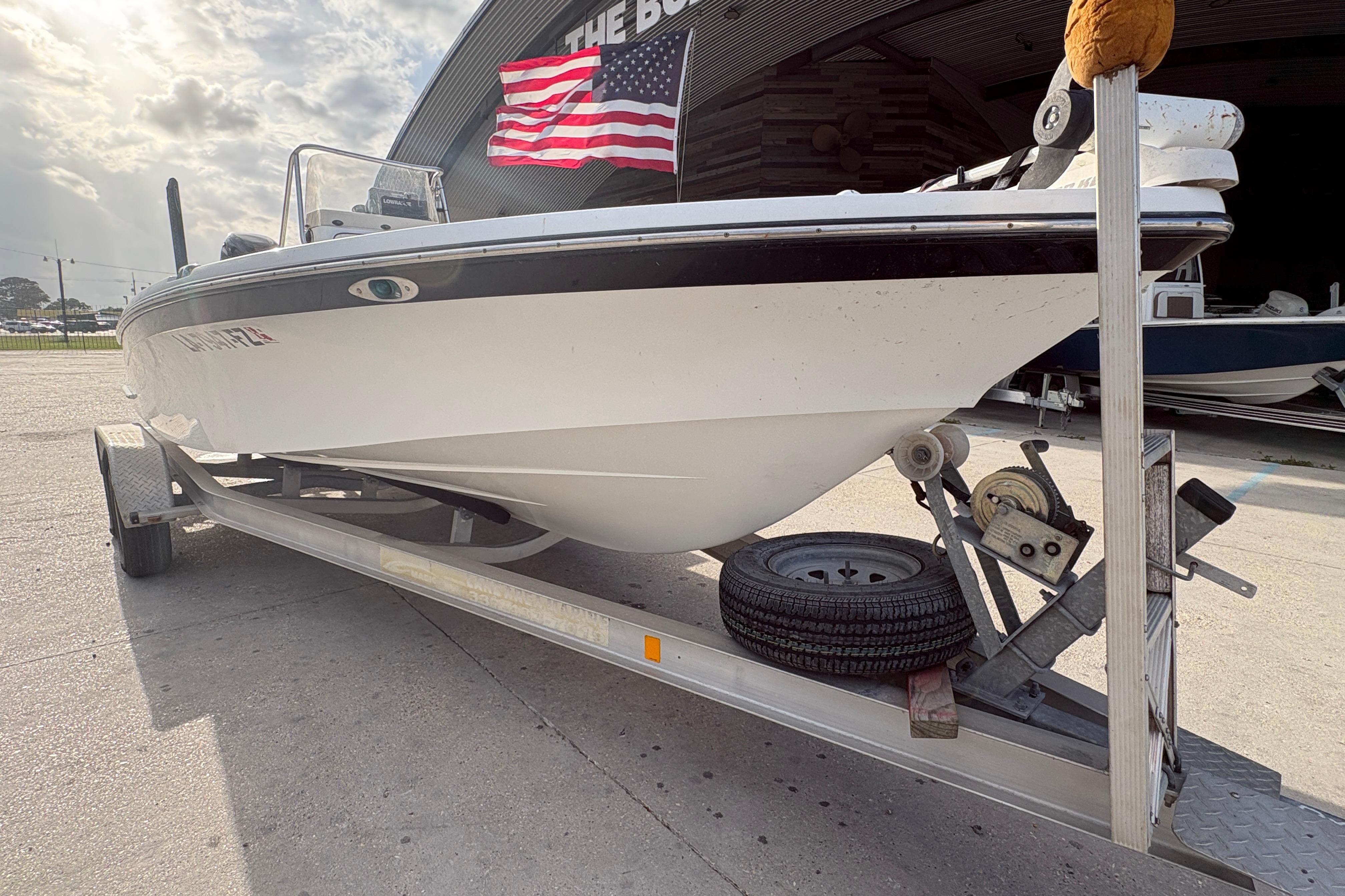 2012 BlackJack 224 boat on trailer with American flag in background.