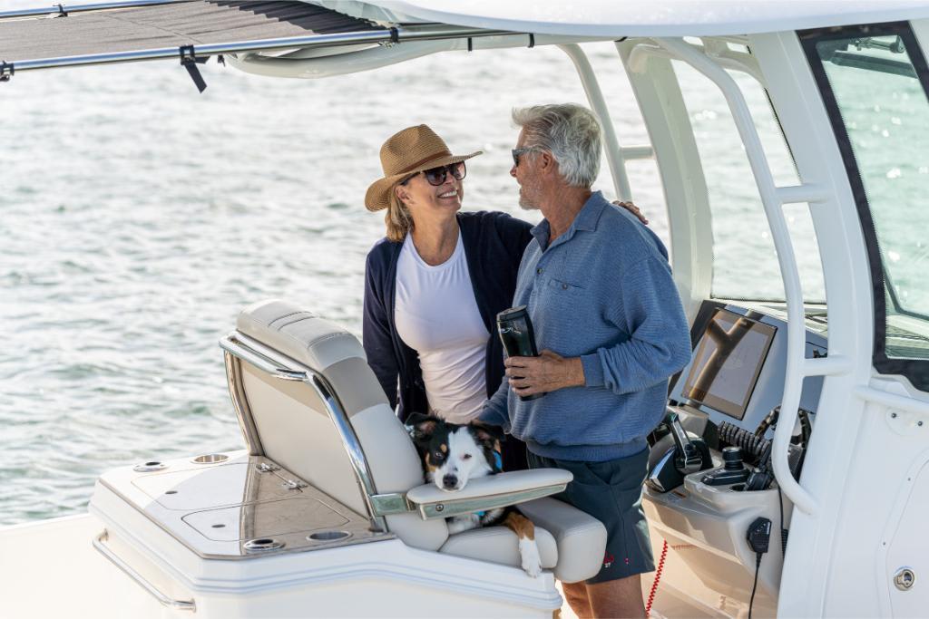 Couple enjoying a day on their 2024 Boston Whaler 280 Dauntless boat with their dog.