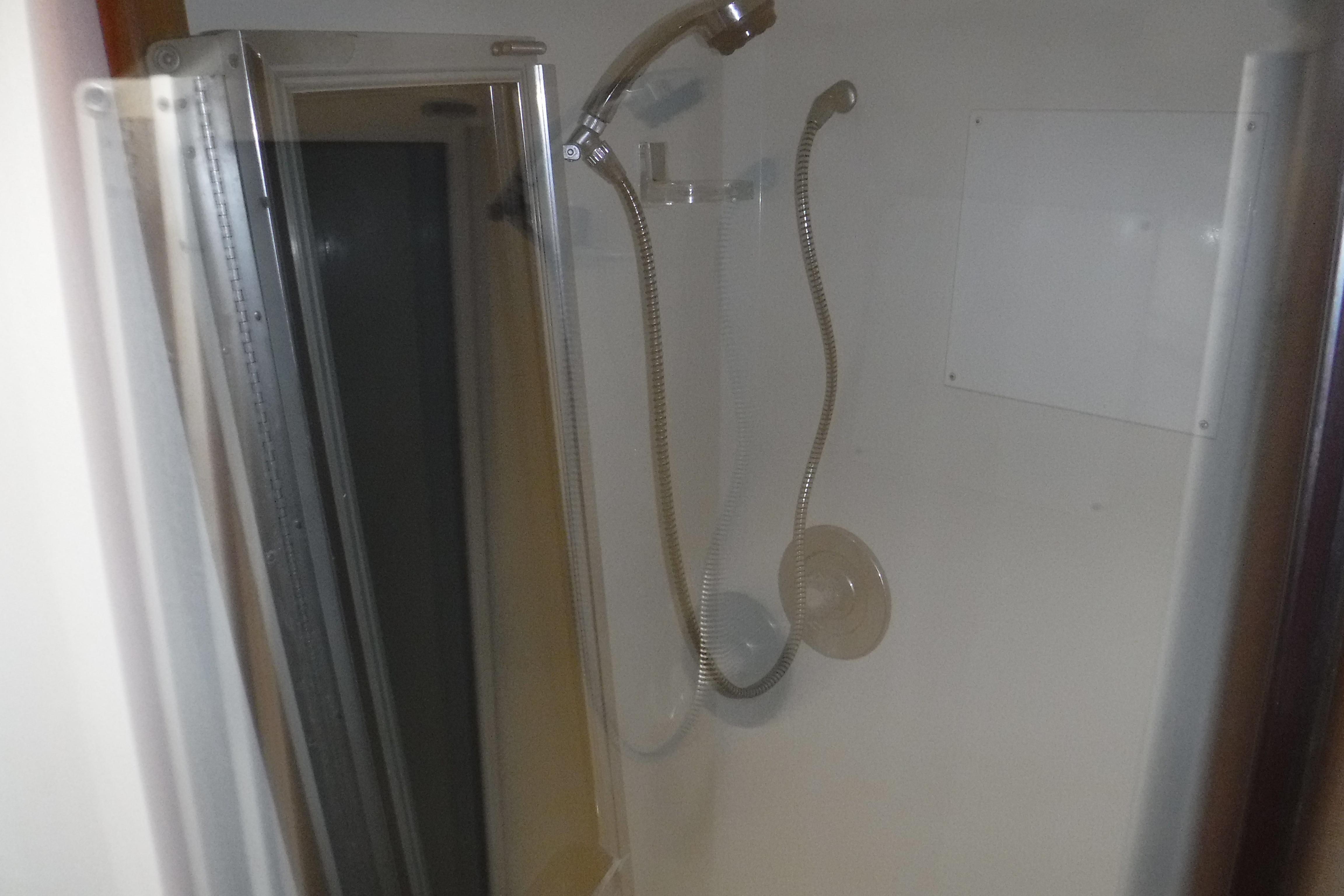 Shower area inside 1989 Viking 41 Sportfish Convertible boat, featuring a flexible showerhead.