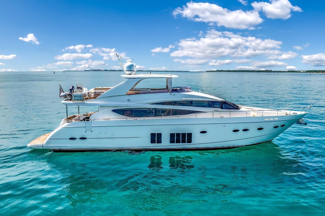 Luxurious 2012 Princess 85 yacht cruising on clear blue ocean under a sunny sky.
