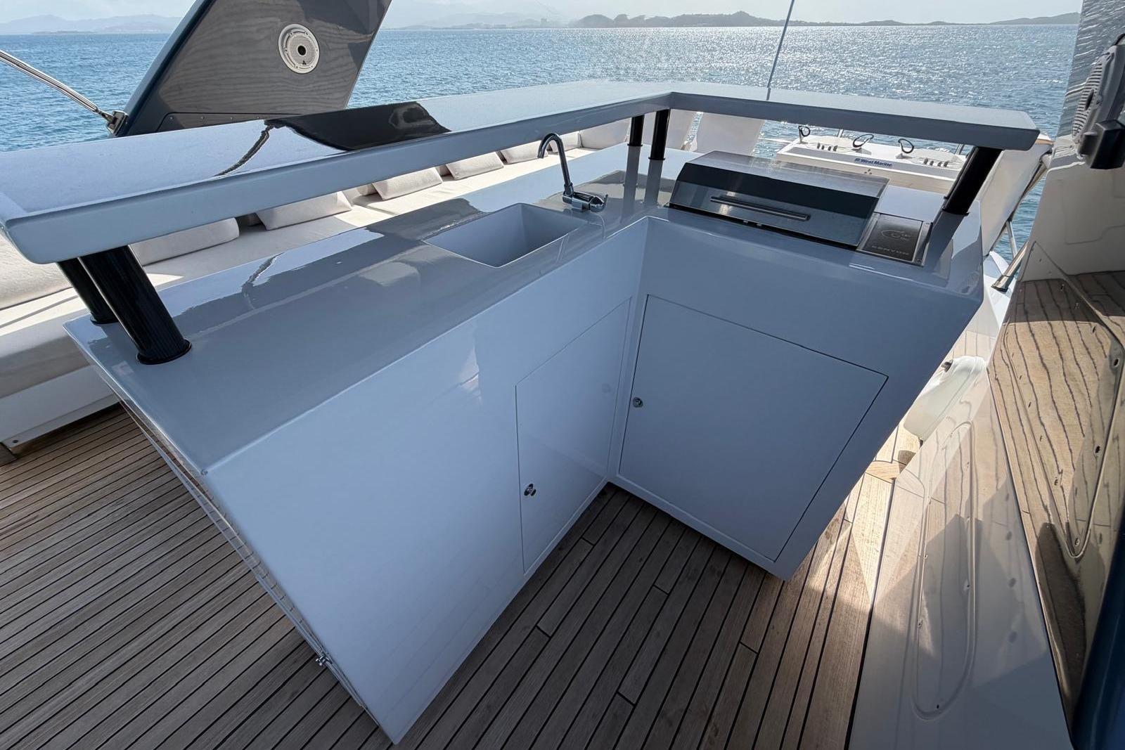 Outdoor kitchen on 2012 Sanlorenzo SL72 yacht with sink and grill, overlooking the sea.