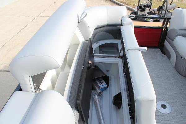 2025 Regency 230 DL3 pontoon boat with open storage compartment and cushioned seating.