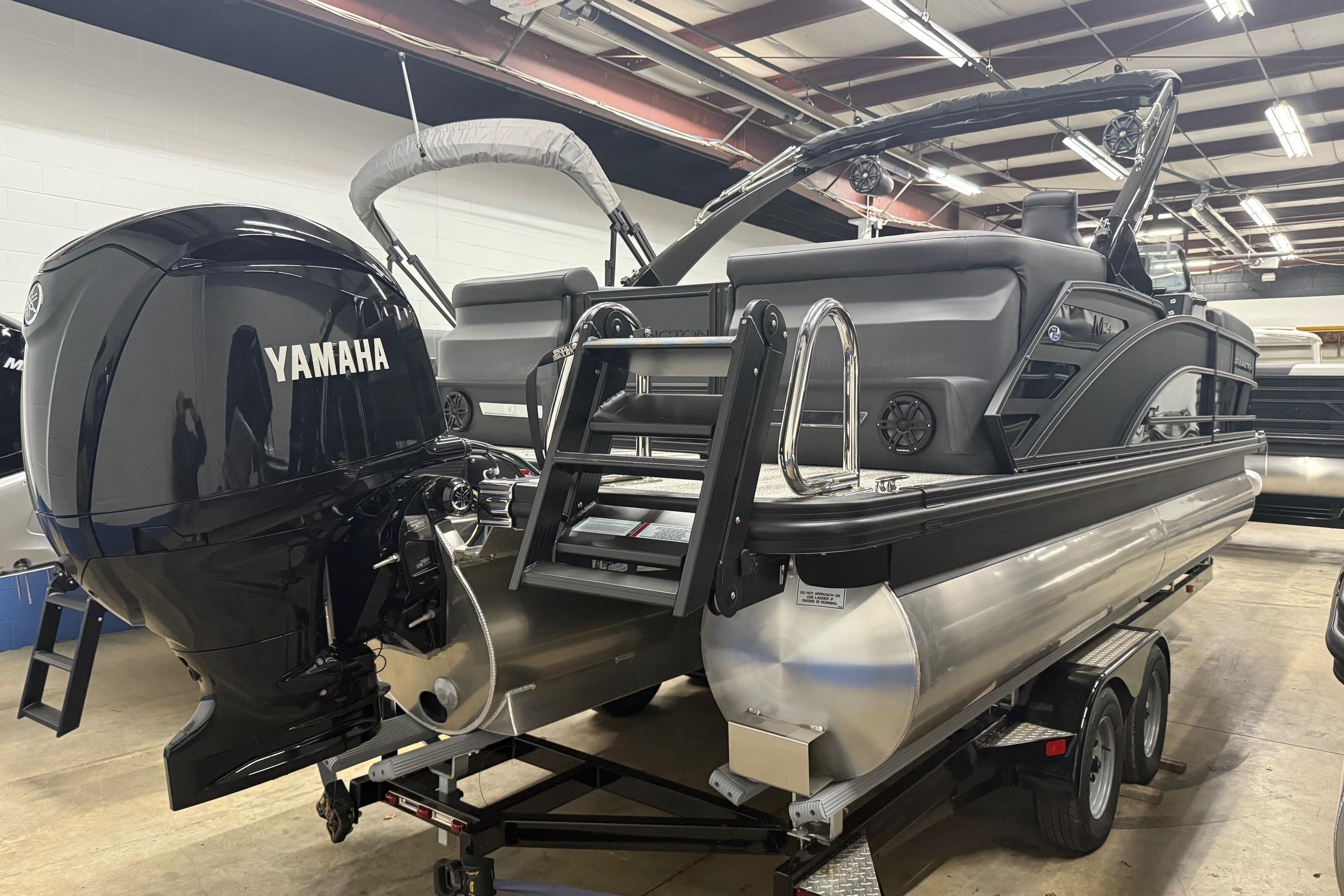 2025 Bennington M Line pontoon boat with Yamaha outboard motor in showroom.