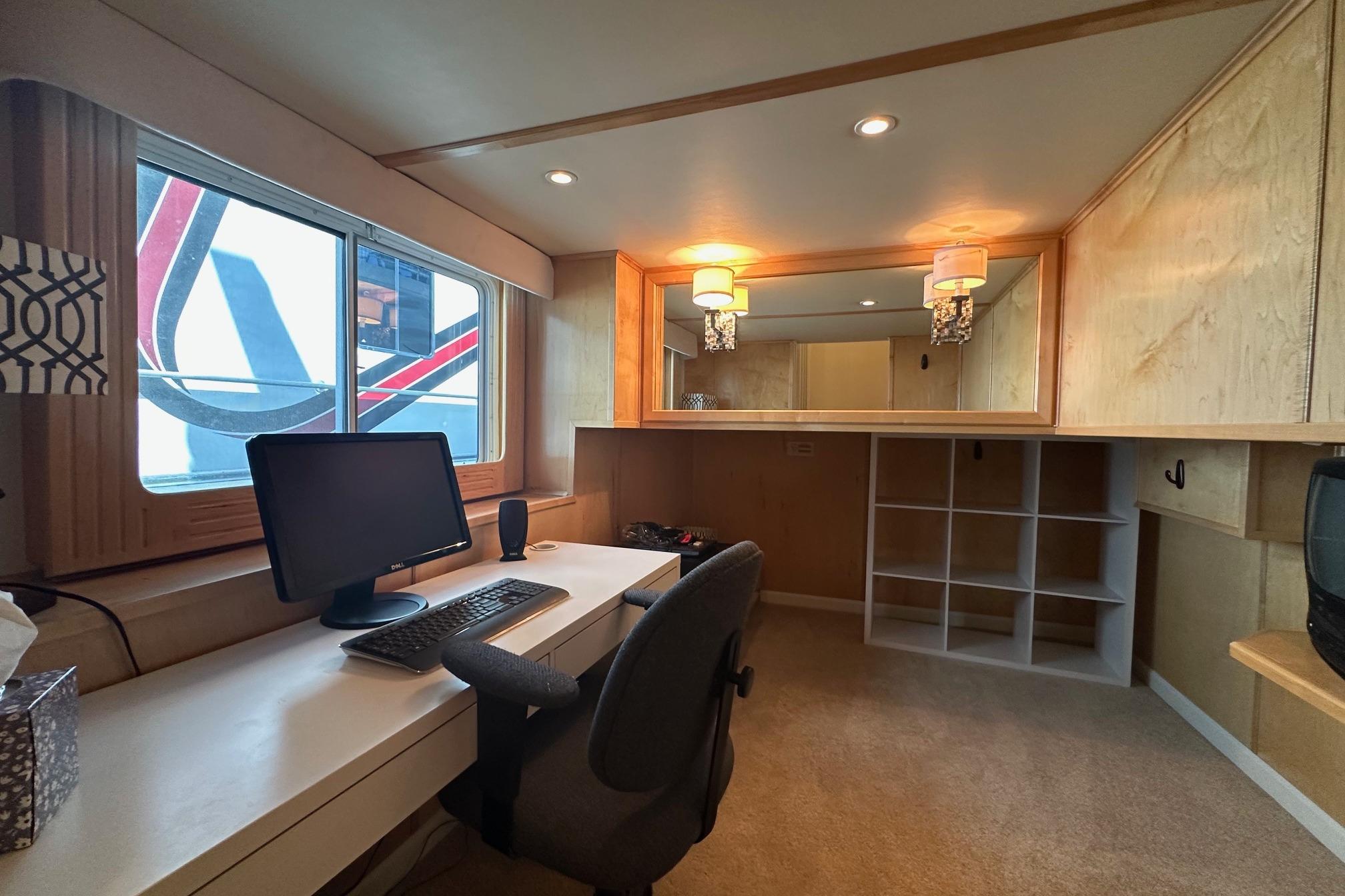 Modern office space in a 2006 Thoroughbred 20x90, featuring a desk and computer setup.