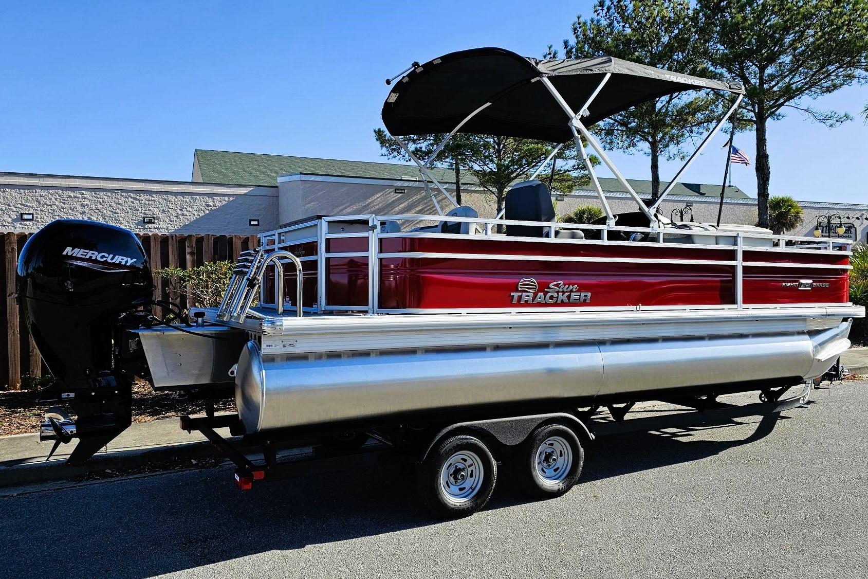 2026 Sun Tracker Fishin' Barge 22 DLX pontoon boat with Mercury engine on trailer.