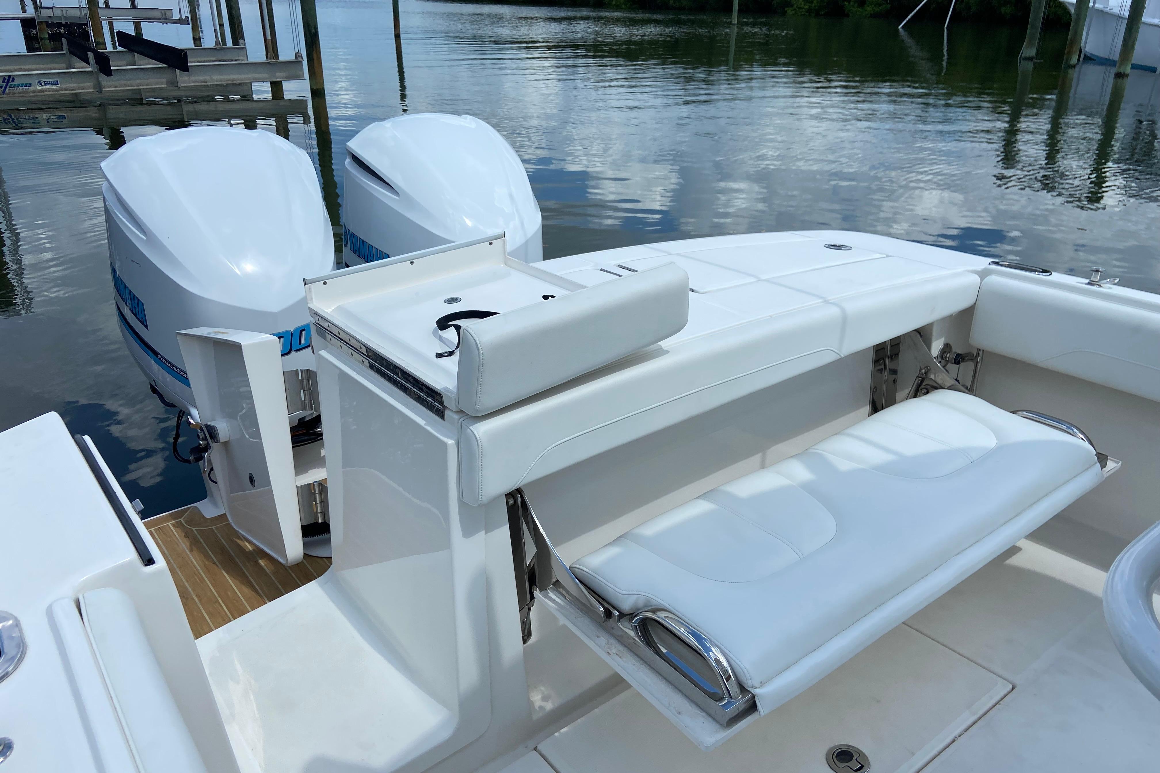 2021 Regulator 28 boat with dual outboard engines and white seating, docked by calm waters.