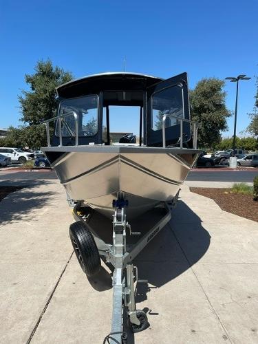 2024 Spartan 220 Maximus boat on trailer, parked outdoors under clear blue sky.