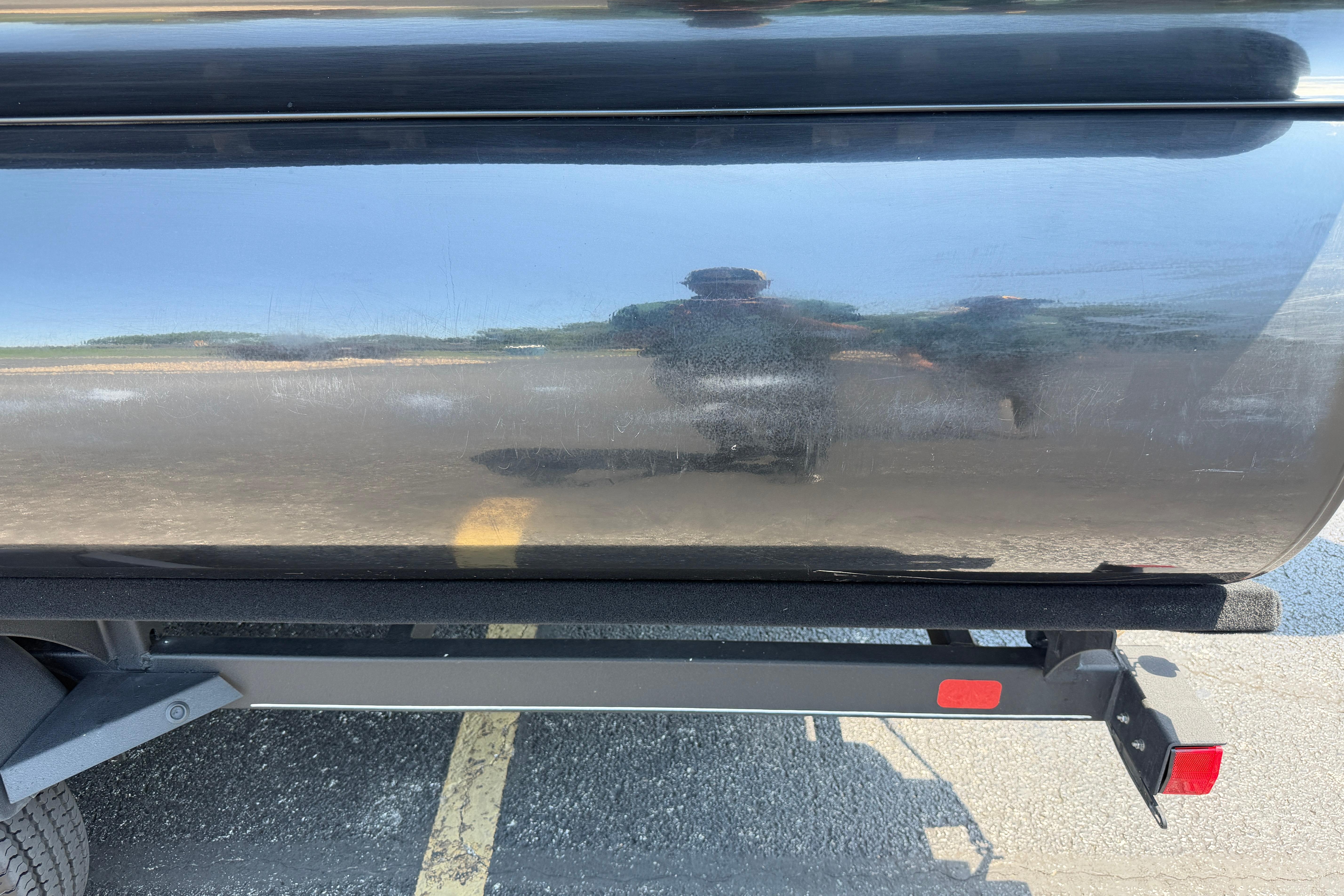 2024 Regency R250DL3 boat trailer with reflective black surface in parking lot.