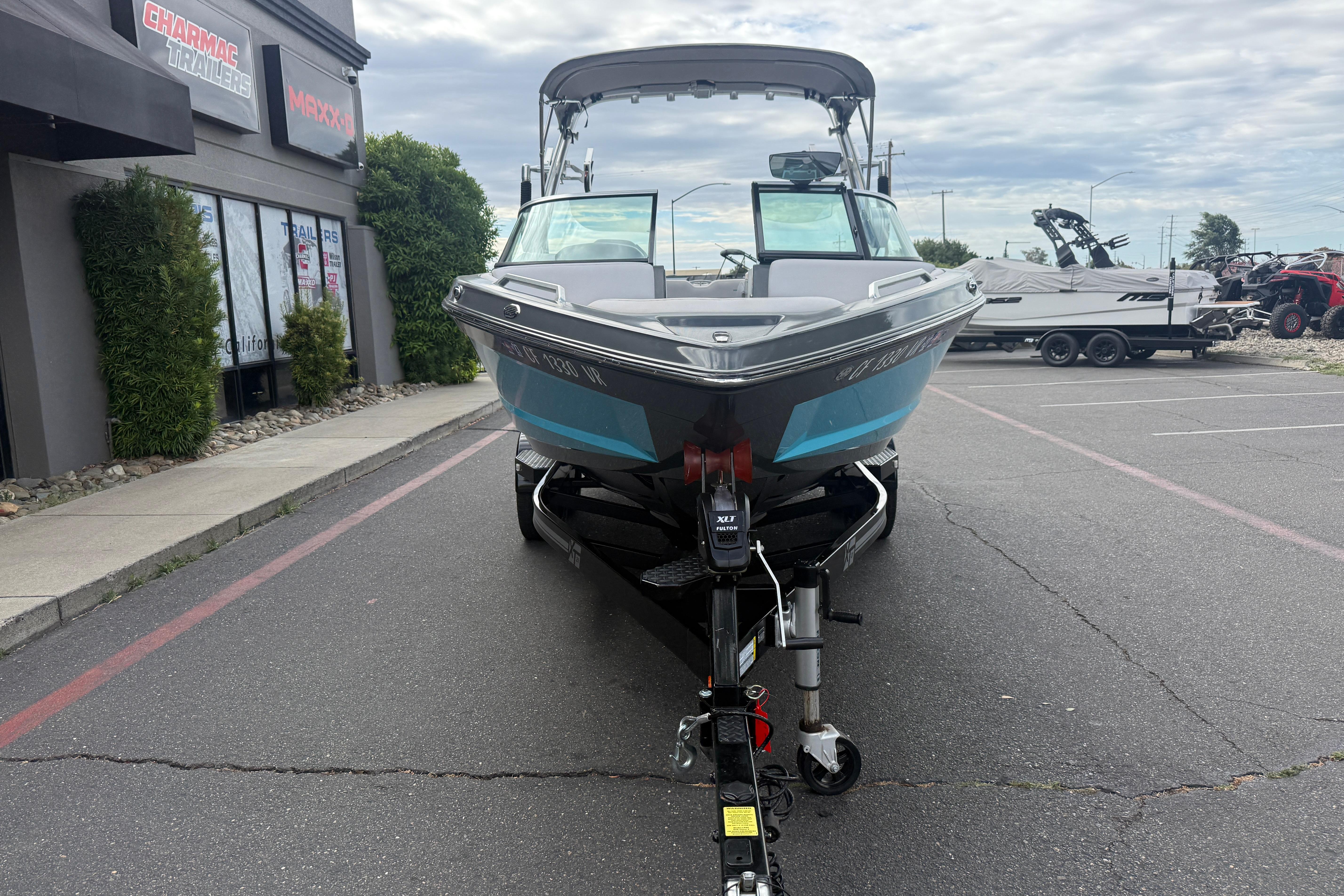 2018 MasterCraft XT21 boat on trailer in parking lot, overcast sky.
