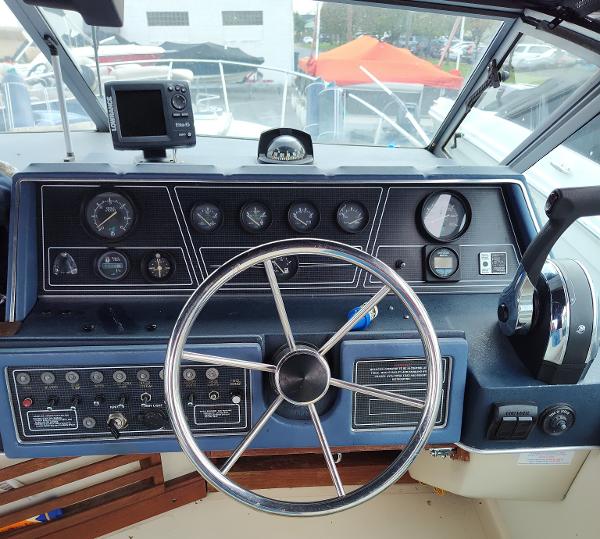 Dashboard of a 1988 Sea Ray 268 DA boat with steering wheel and gauges.