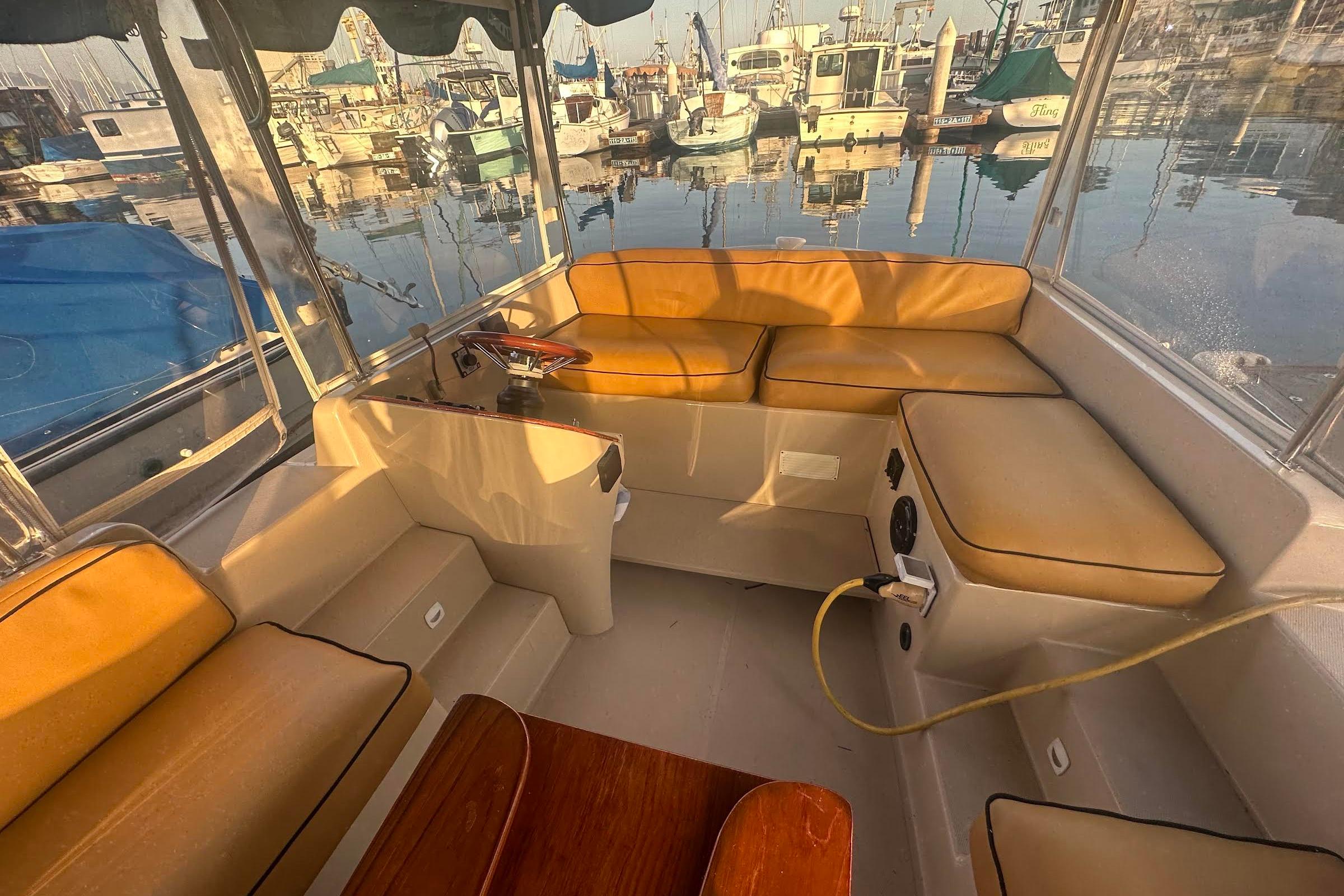 Interior of a 2007 Duffy 22 Electric boat with tan seating and marina view.