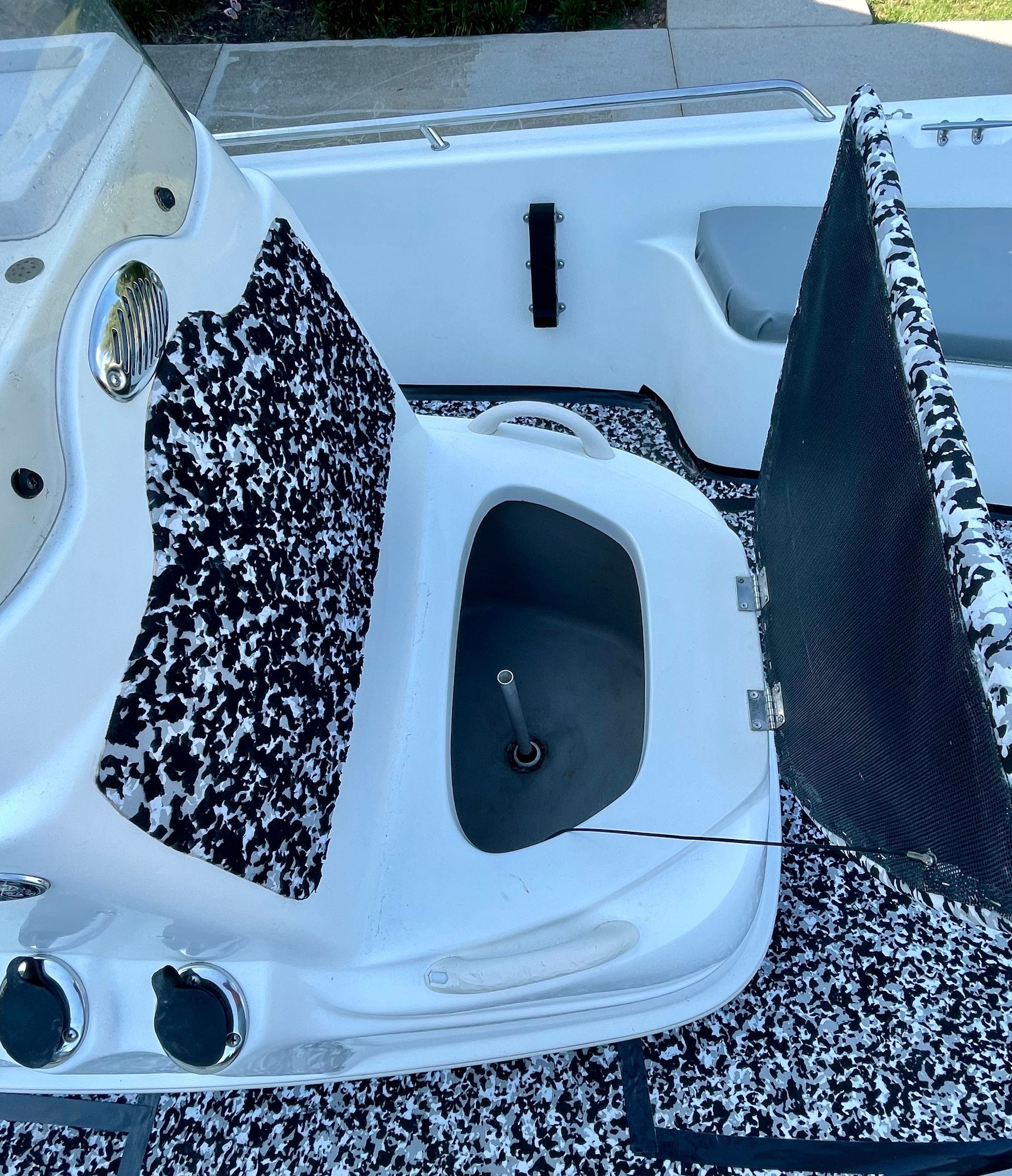The image shows the cockpit of a 2006 Mako 2101 Inshore boat with an open storage compartment.