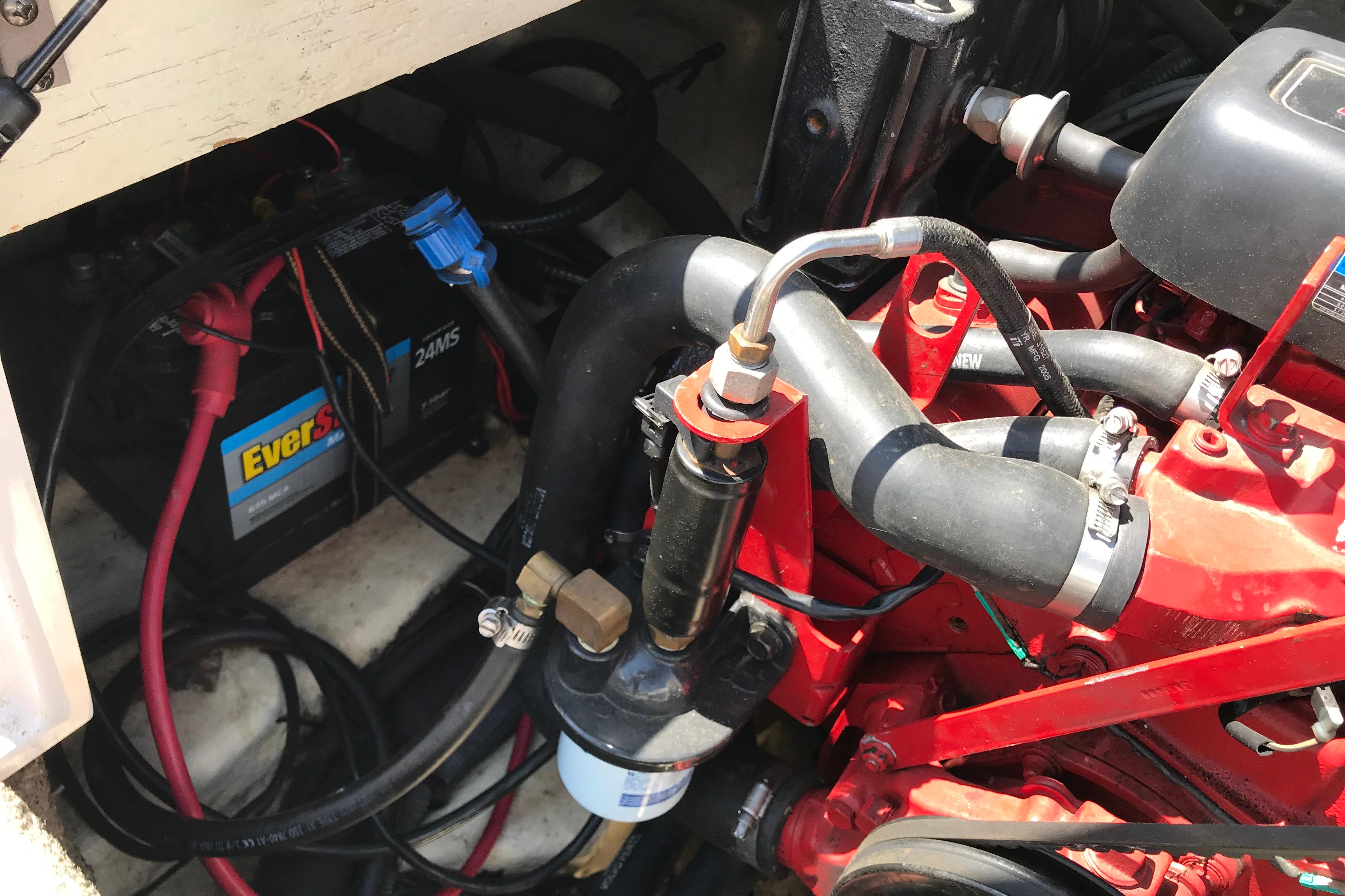 Engine compartment of 2005 Four Winns 180 Horizon FS boat, showing battery and hoses.