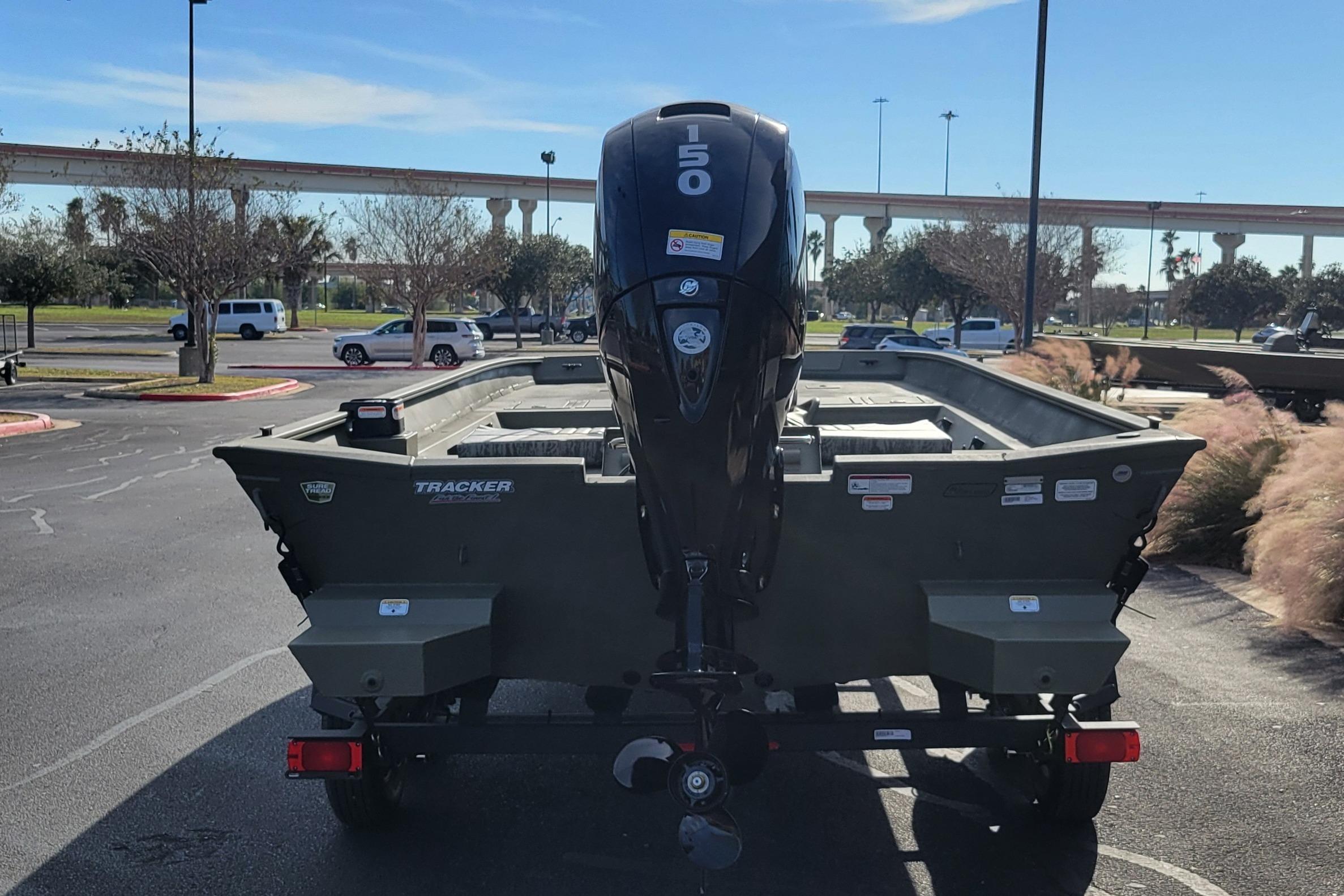 2026 Tracker Grizzly 2072 CC boat with 150 HP motor in parking lot.