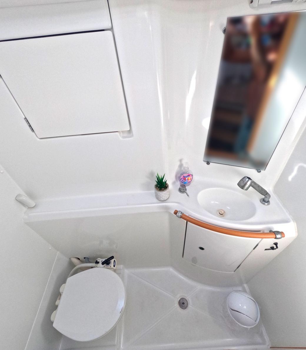Compact bathroom in 2016 Lagoon 380 S2 yacht with sink, toilet, and mirror.