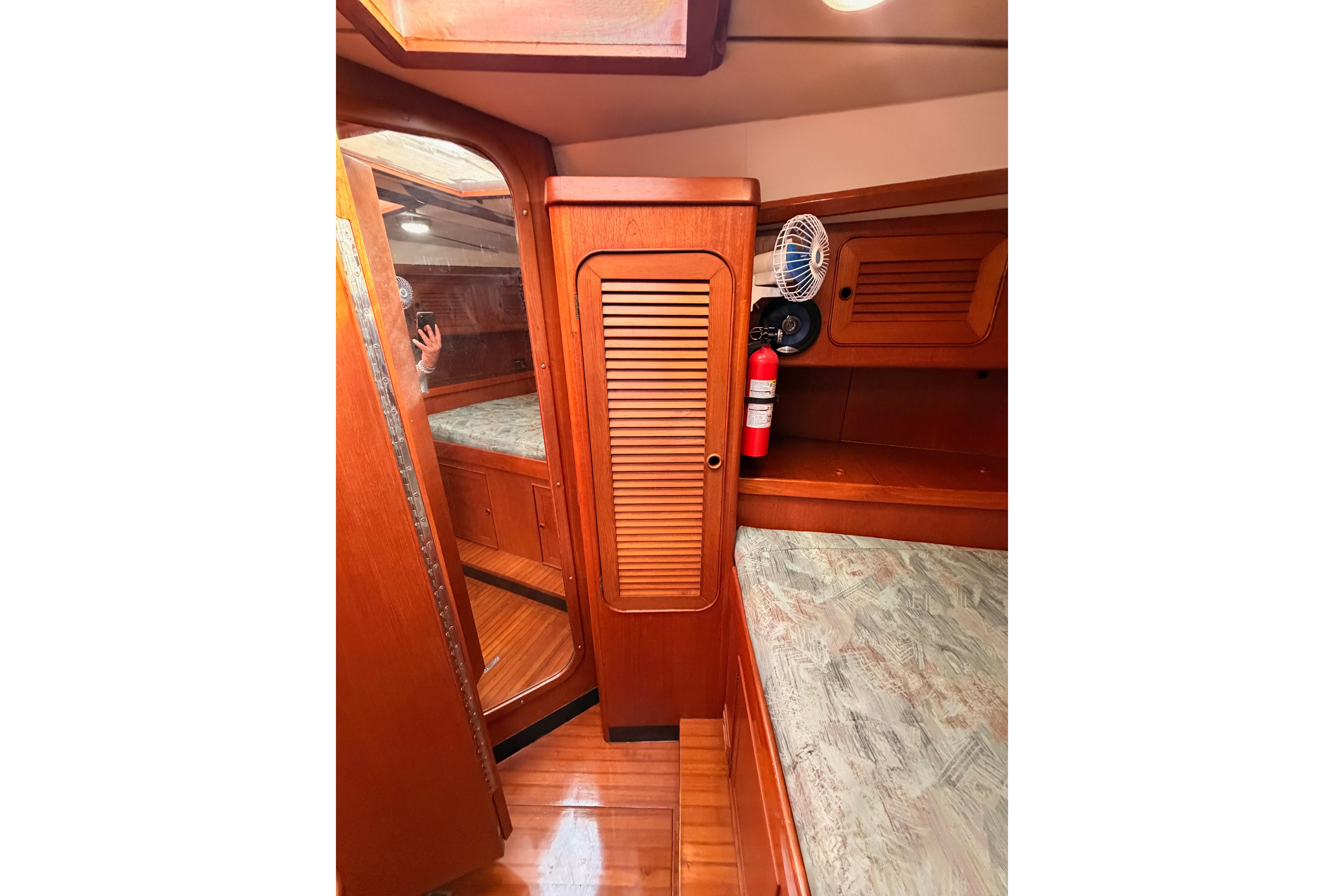 Interior of 1991 Hylas 51 yacht with wooden cabinetry and cozy sleeping area.