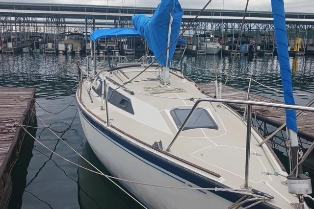 1989 O'Day 272 sailboat docked at marina, featuring blue sail cover and sleek design.