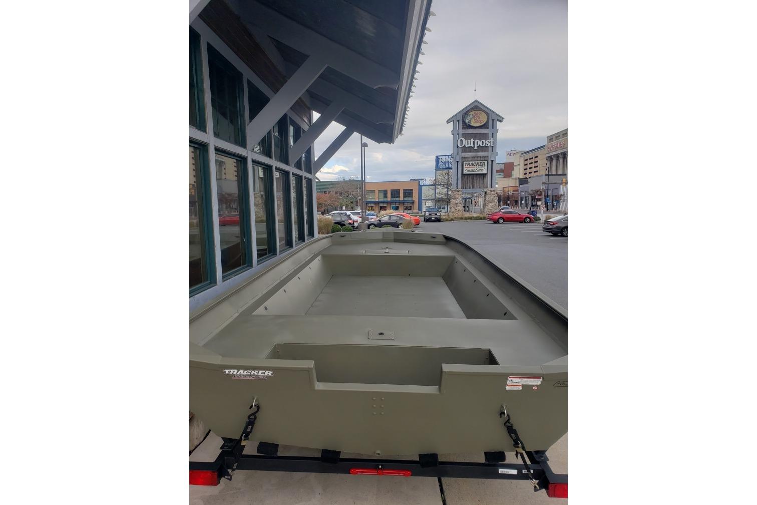 2025 Tracker Grizzly 2072 Utility boat parked outside a shopping center.