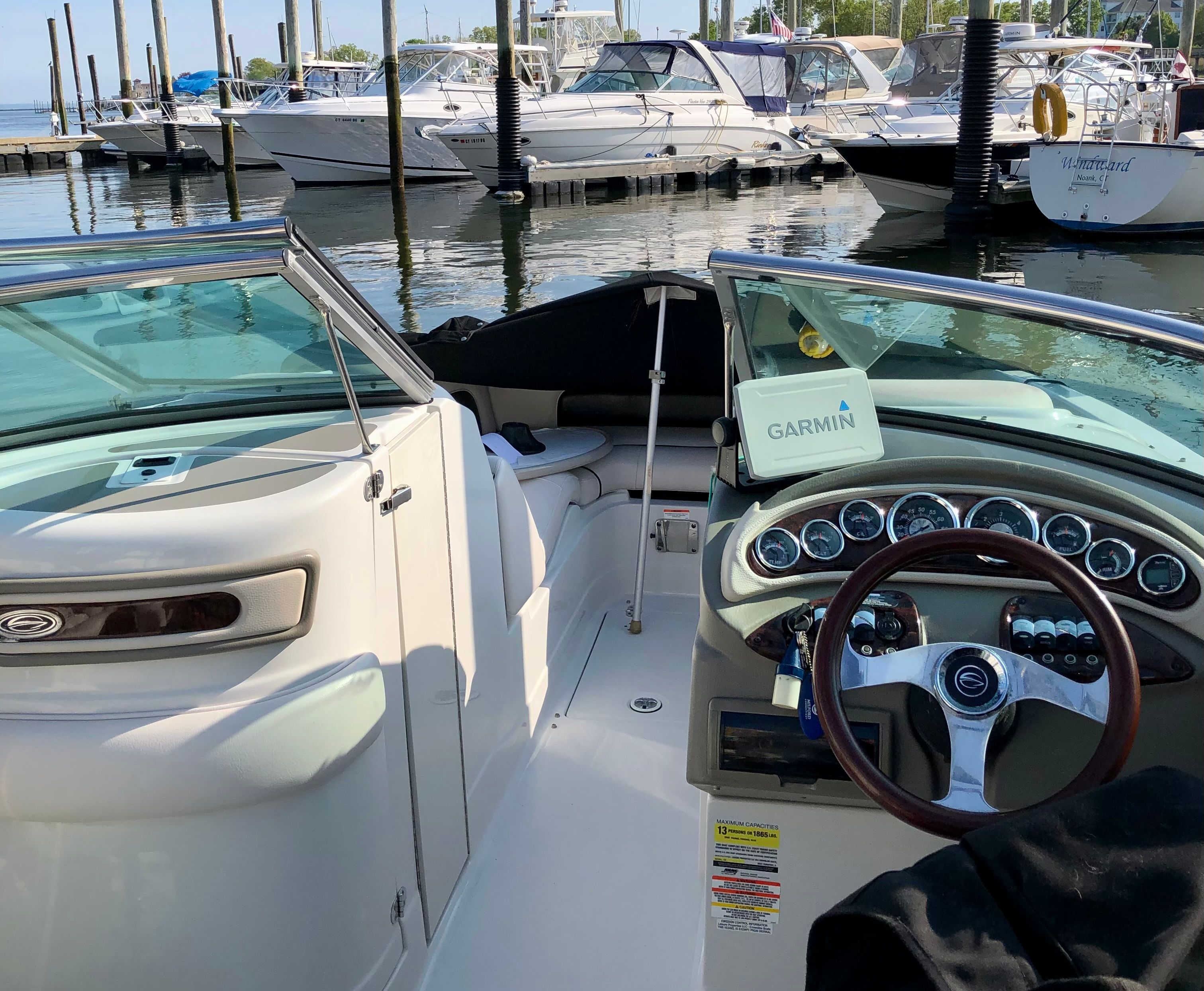 The image shows the cockpit of a 2013 Crownline E-4 Bowrider at a marina.