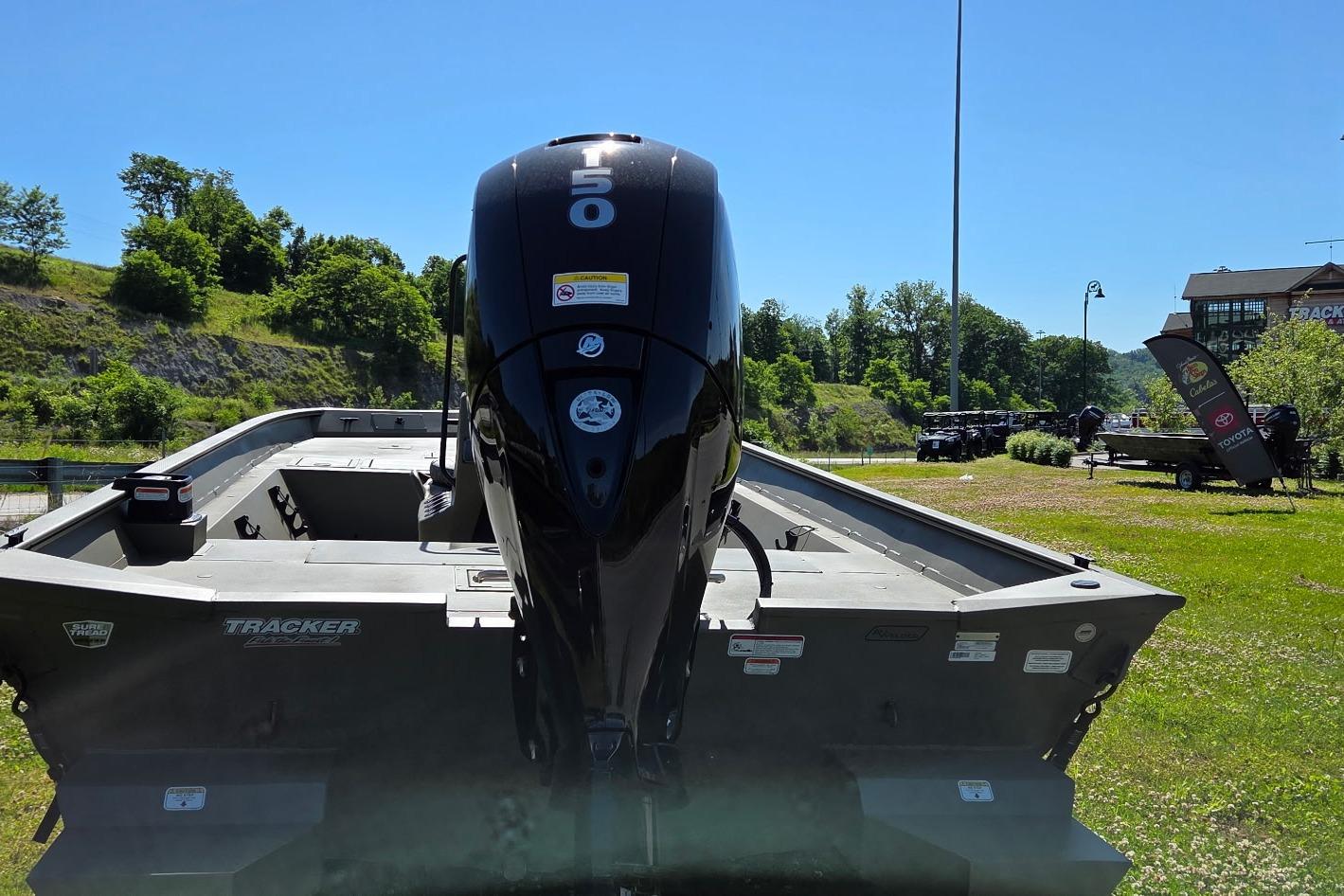 2026 Tracker Grizzly 2072 CC boat with powerful outboard motor, parked outdoors.