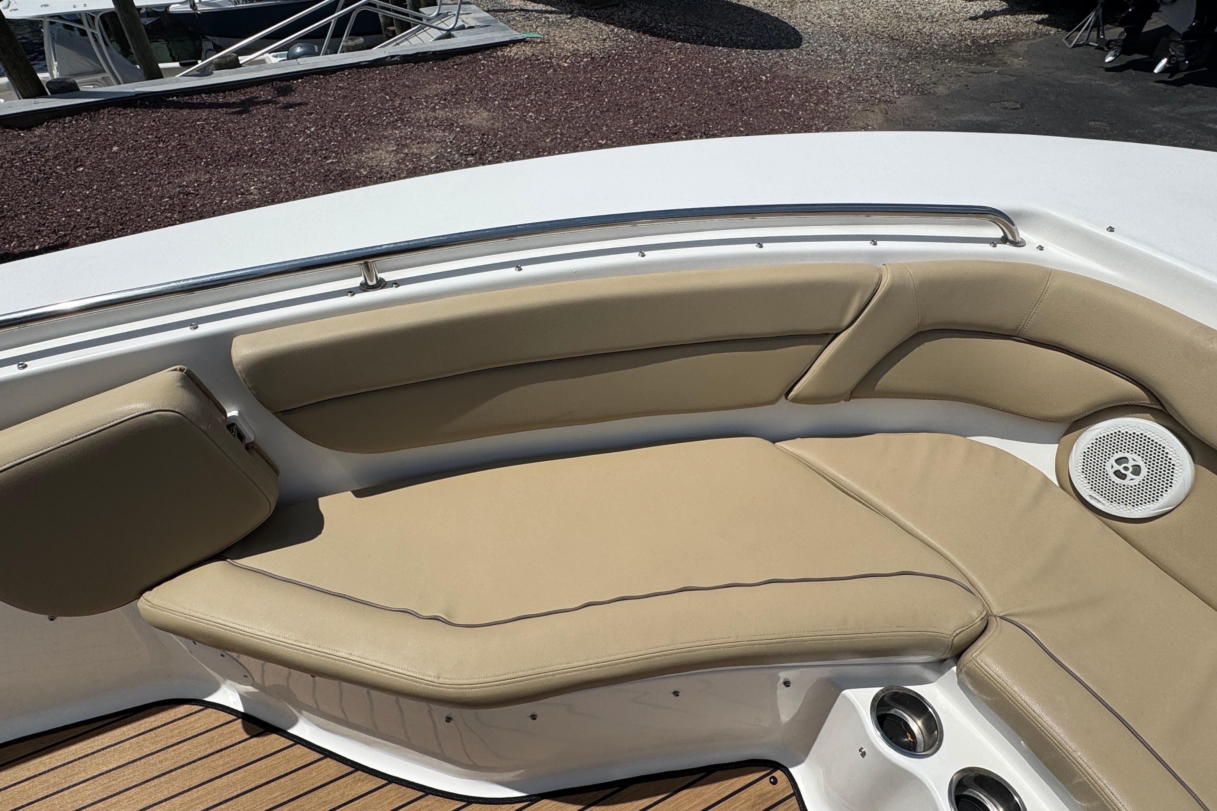 2016 Tidewater 230 LXF boat interior with beige cushioned seating and speaker.