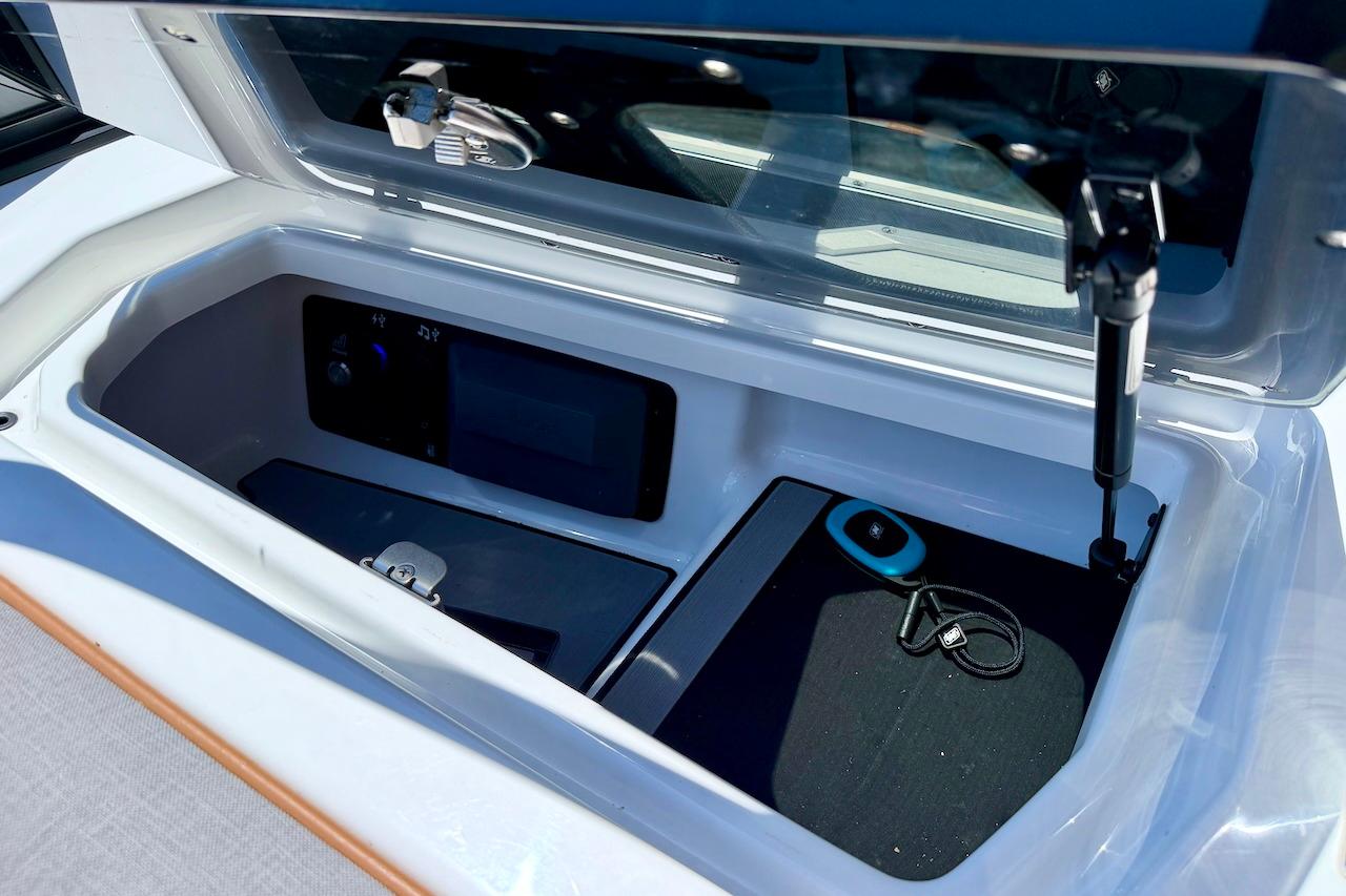 Storage compartment of 2021 Nautique Super Air Nautique G23 boat, featuring modern controls and accessories.