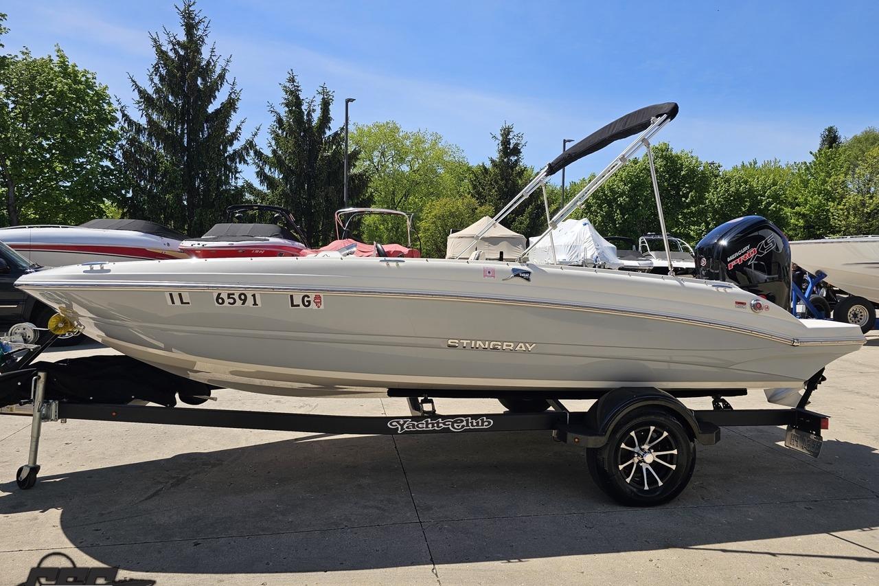 2023 Stingray 182 SC boat on trailer, parked outdoors under clear blue sky.