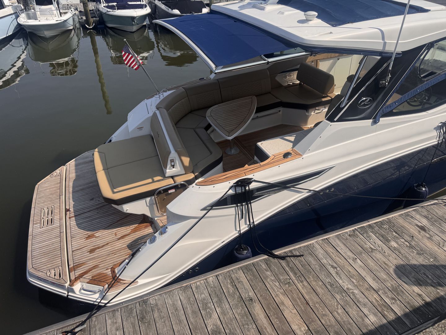 A 2019 Sea Ray Sundancer 320 docked. It features a sleek design with a spacious seating area.