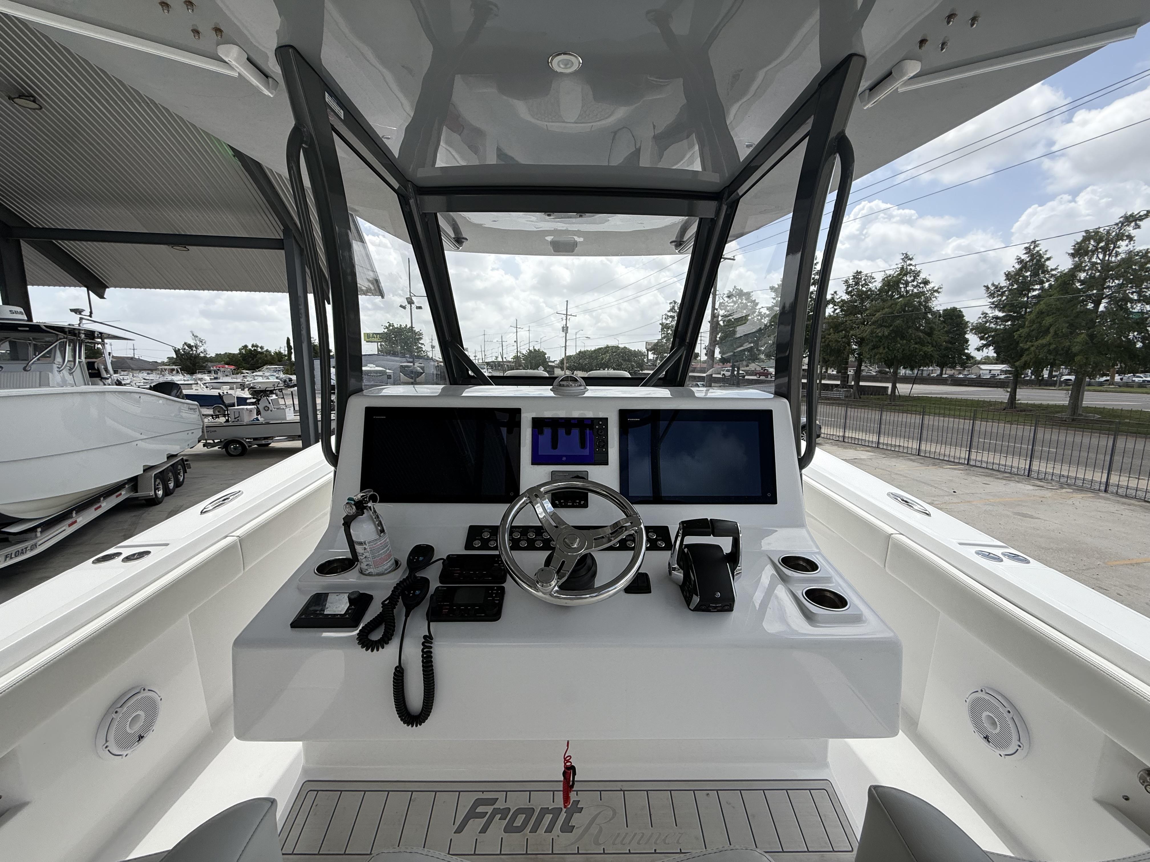 2024 Front Runner 39 CC boat cockpit with modern navigation equipment and steering wheel.