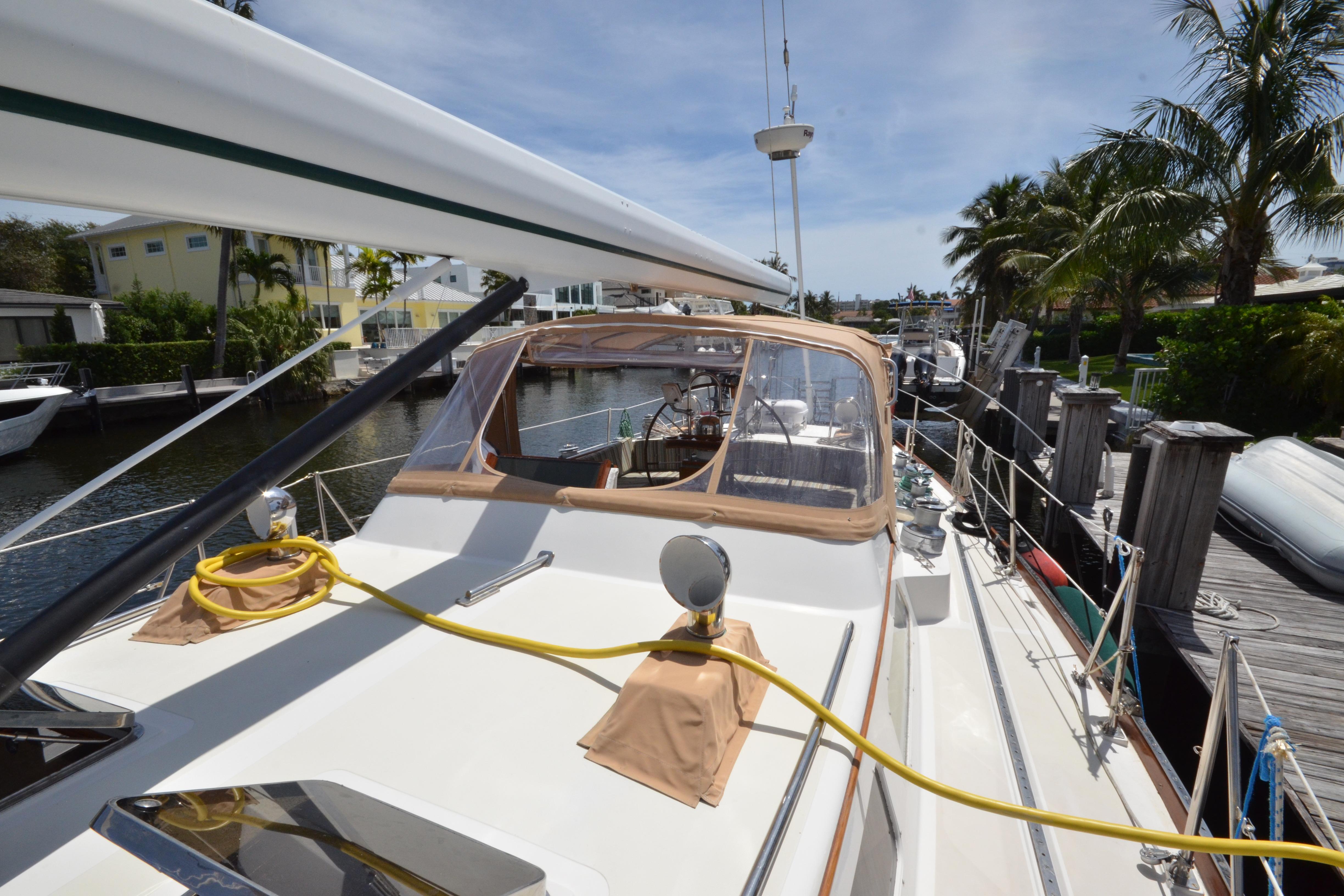 Hinckley Sou'wester 59 yacht docked, showcasing deck and cockpit, surrounded by palm trees.
