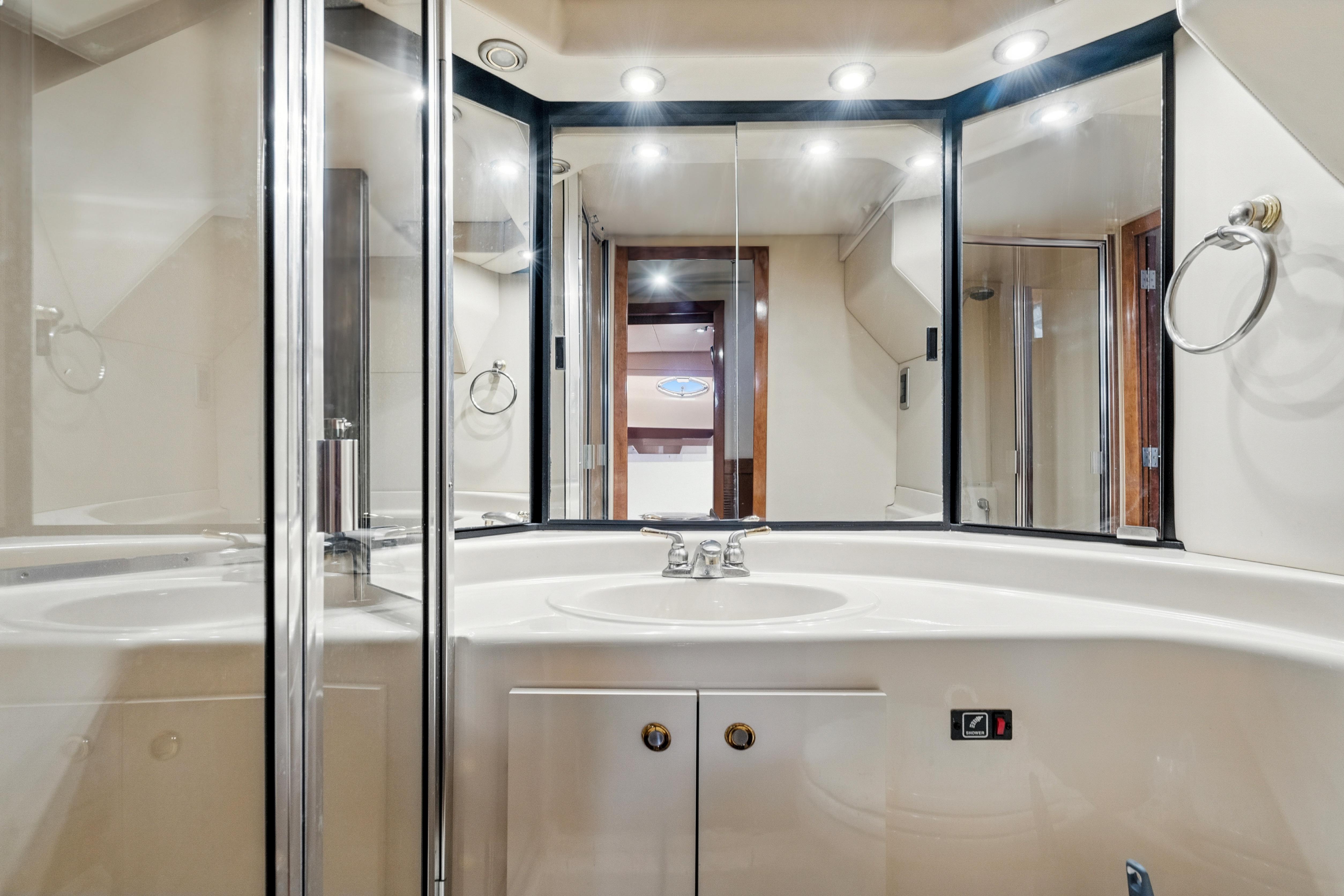 Luxurious bathroom in 2007 Meridian 490 Pilothouse yacht with modern fixtures and mirrors.