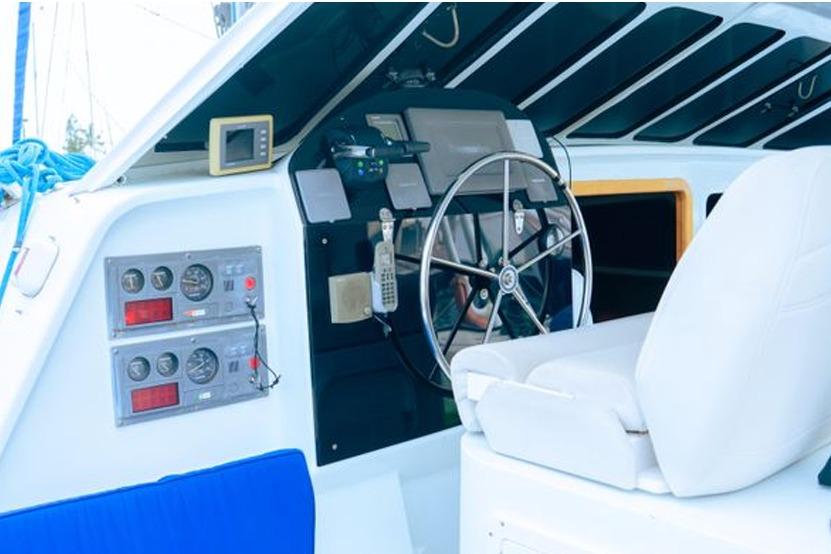 Luxury yacht cockpit with steering wheel, control panels, and white seating, 2005 model.
